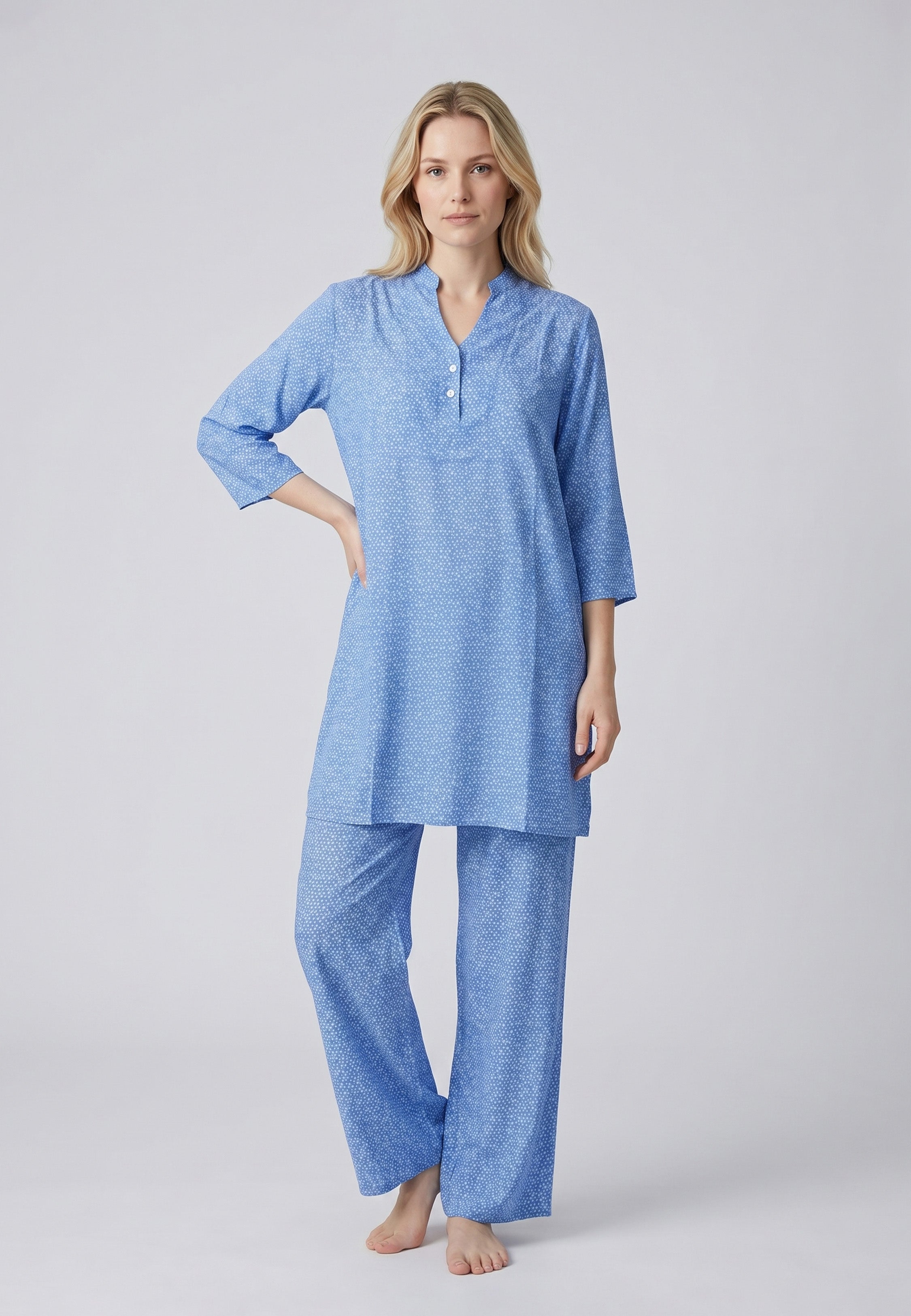 Femme portant un pyjama deux pièces bleu à imprimé pois blancs