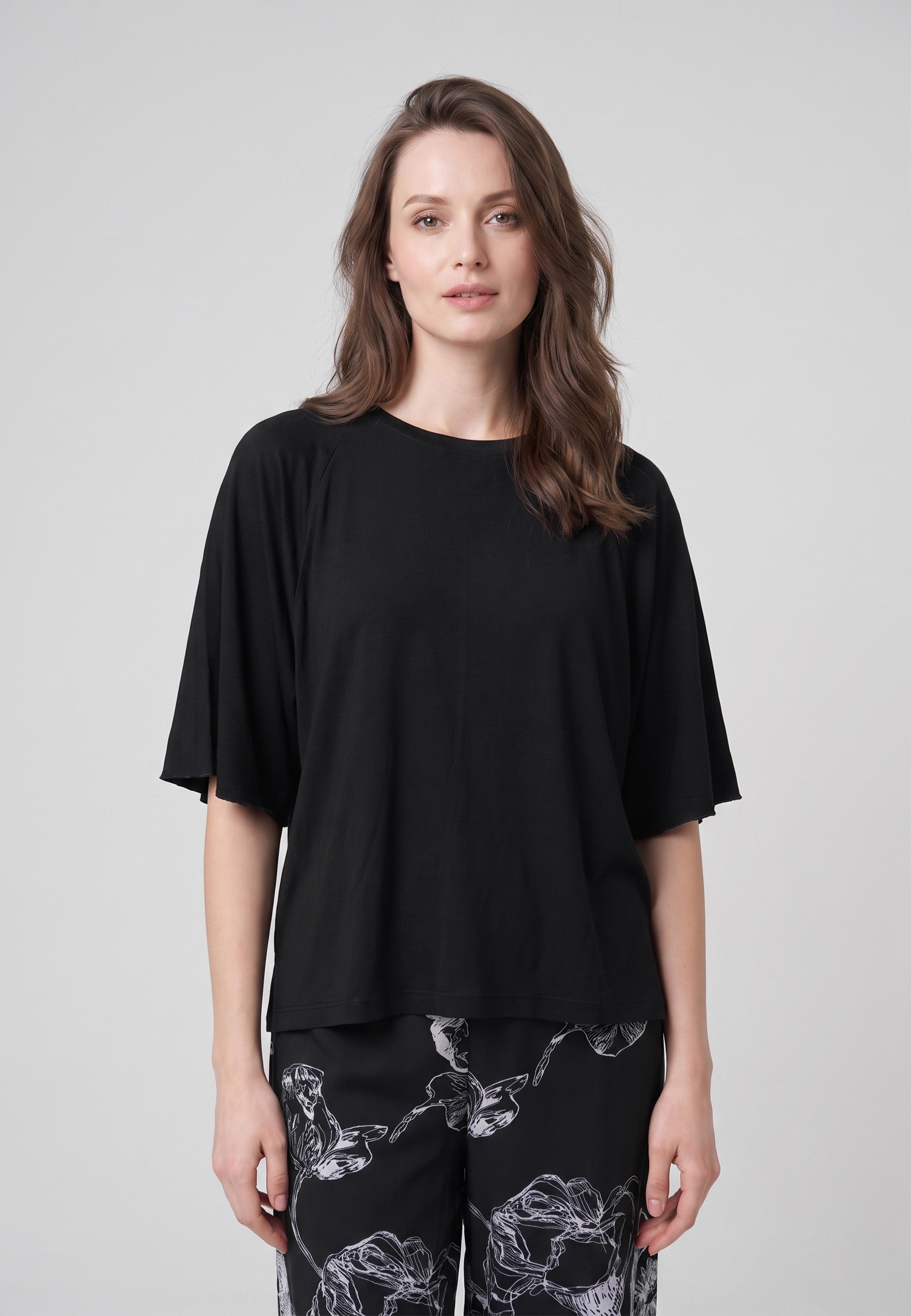 Pyjama pantalon long deux pièces T-shirt col rond noir manches papillon évasées et pantalon large fond noir imprimé grandes fleurs botaniques au trait écru