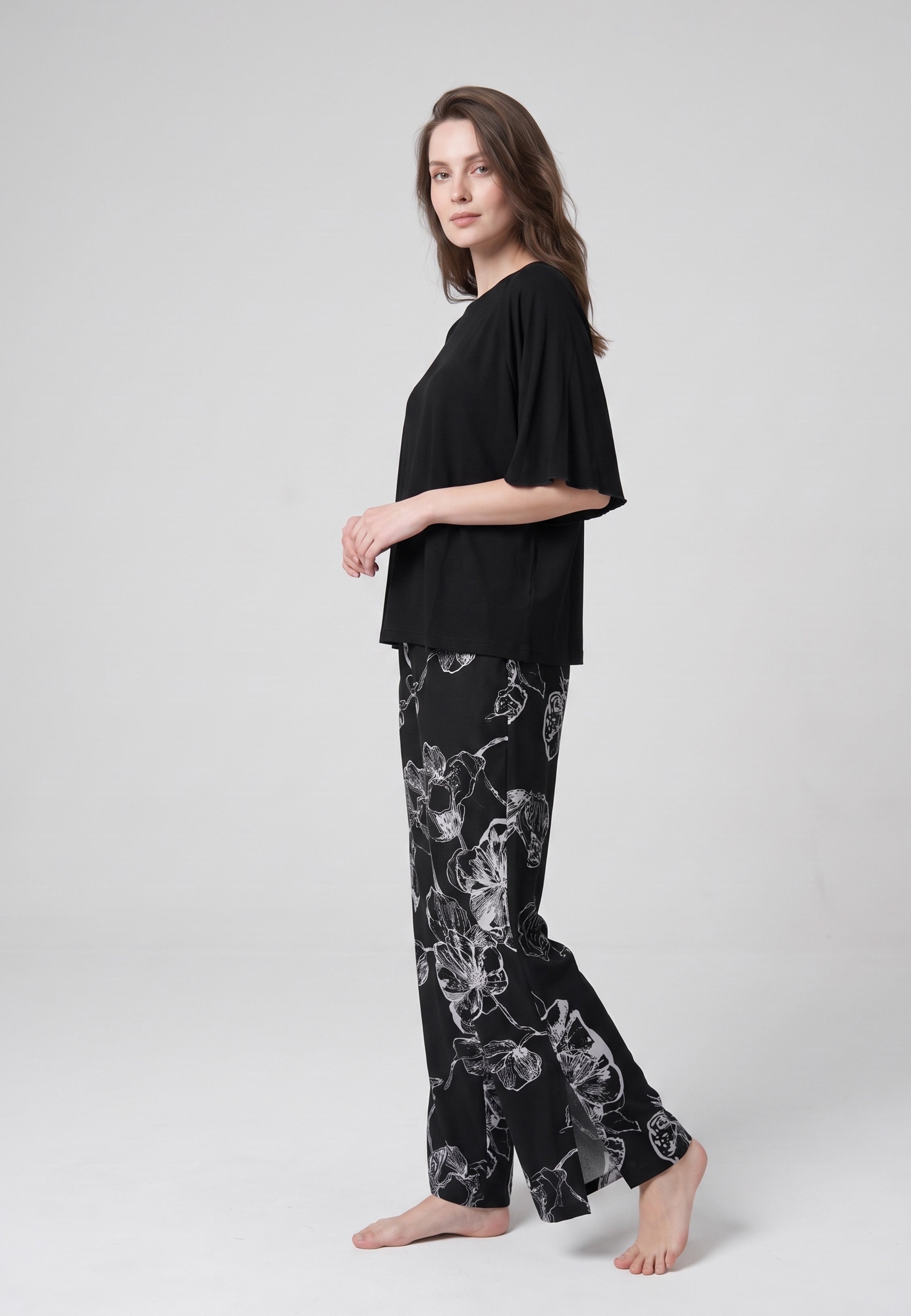 Pyjama pantalon long deux pièces T-shirt col rond noir manches papillon évasées et pantalon large fond noir imprimé grandes fleurs botaniques au trait écru