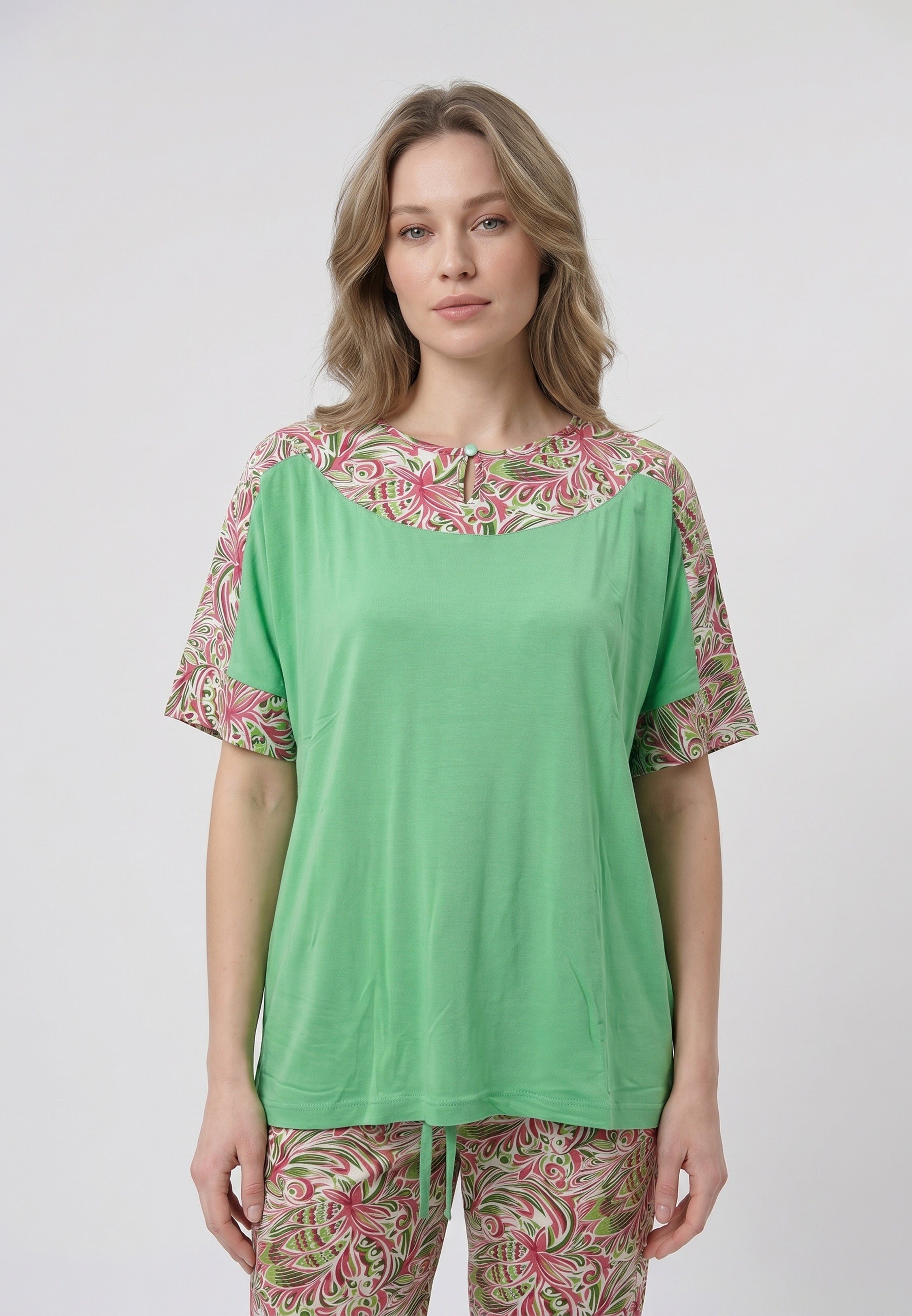 Femme portant un pyjama deux pièces t-shirt vert à empiècement fleuri et pantalon long imprimé ethnique floral multicolore sur fond gris Rosabella Ethnique 2