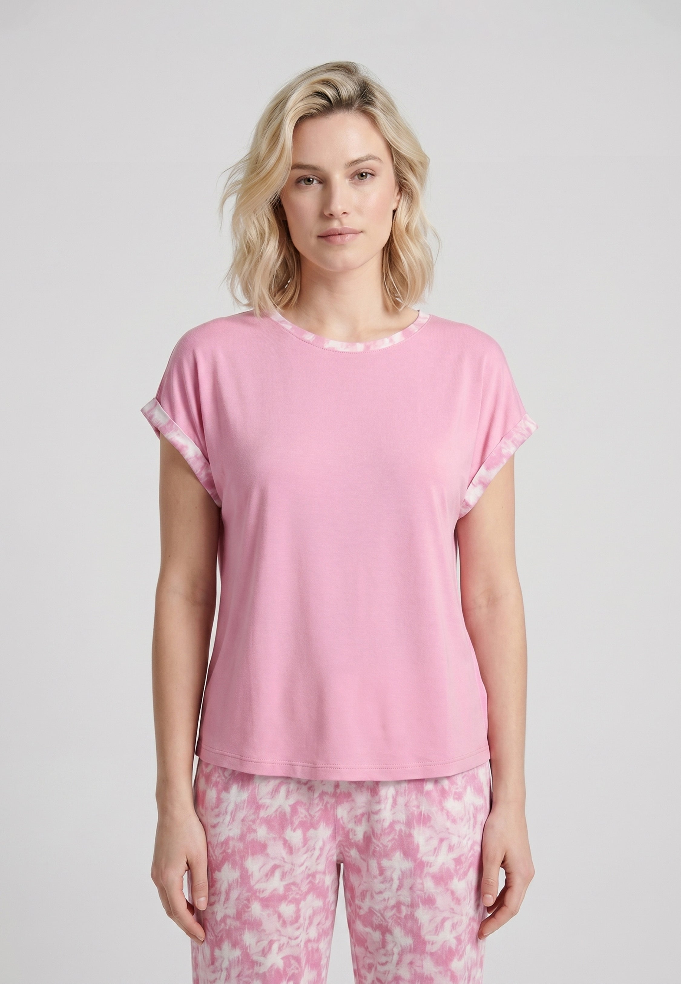 Femme portant un pyjama deux pièces t-shirt rose foncé liseré fleuri au col et manches et pantalon long imprimé aquarelle fleuri multicolore Rosabella Rosalinda