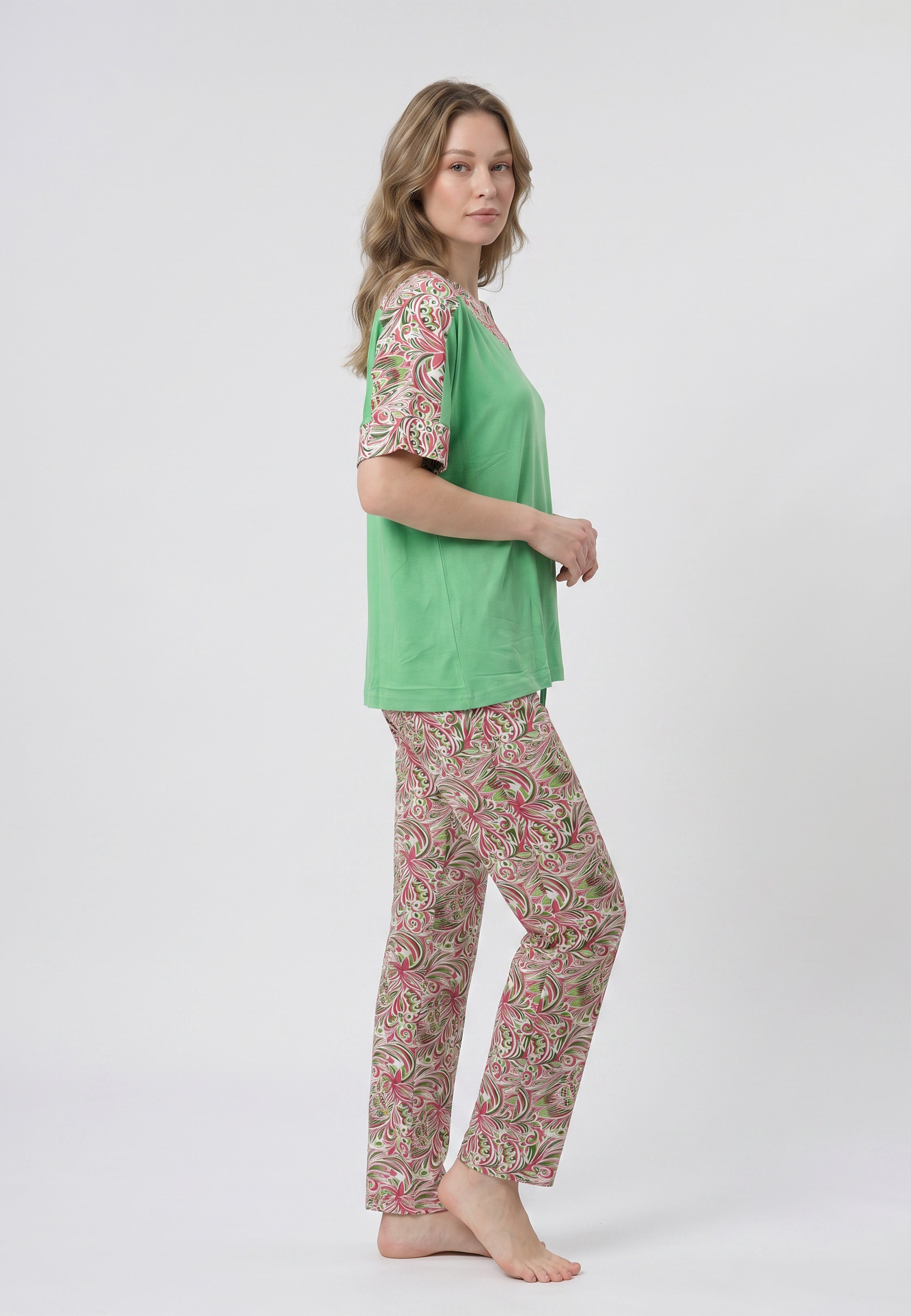 Femme portant un pyjama deux pièces t-shirt vert à empiècement fleuri et pantalon long imprimé ethnique floral multicolore sur fond gris Rosabella Ethnique 2