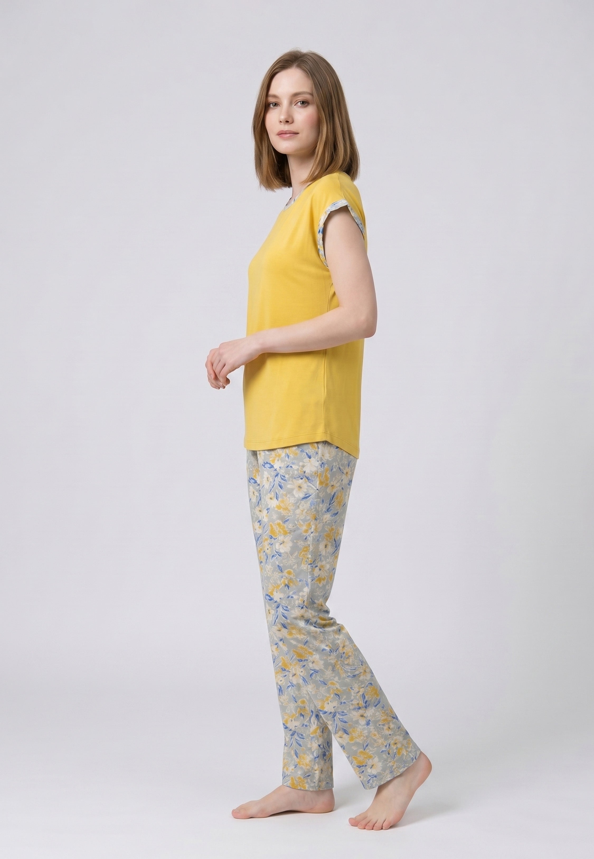 Femme portant un pyjama deux pièces t-shirt moutarde liseré fleuri au col et manches et pantalon long imprimé ethnique floral multicolore Rosabella Ethnique 2