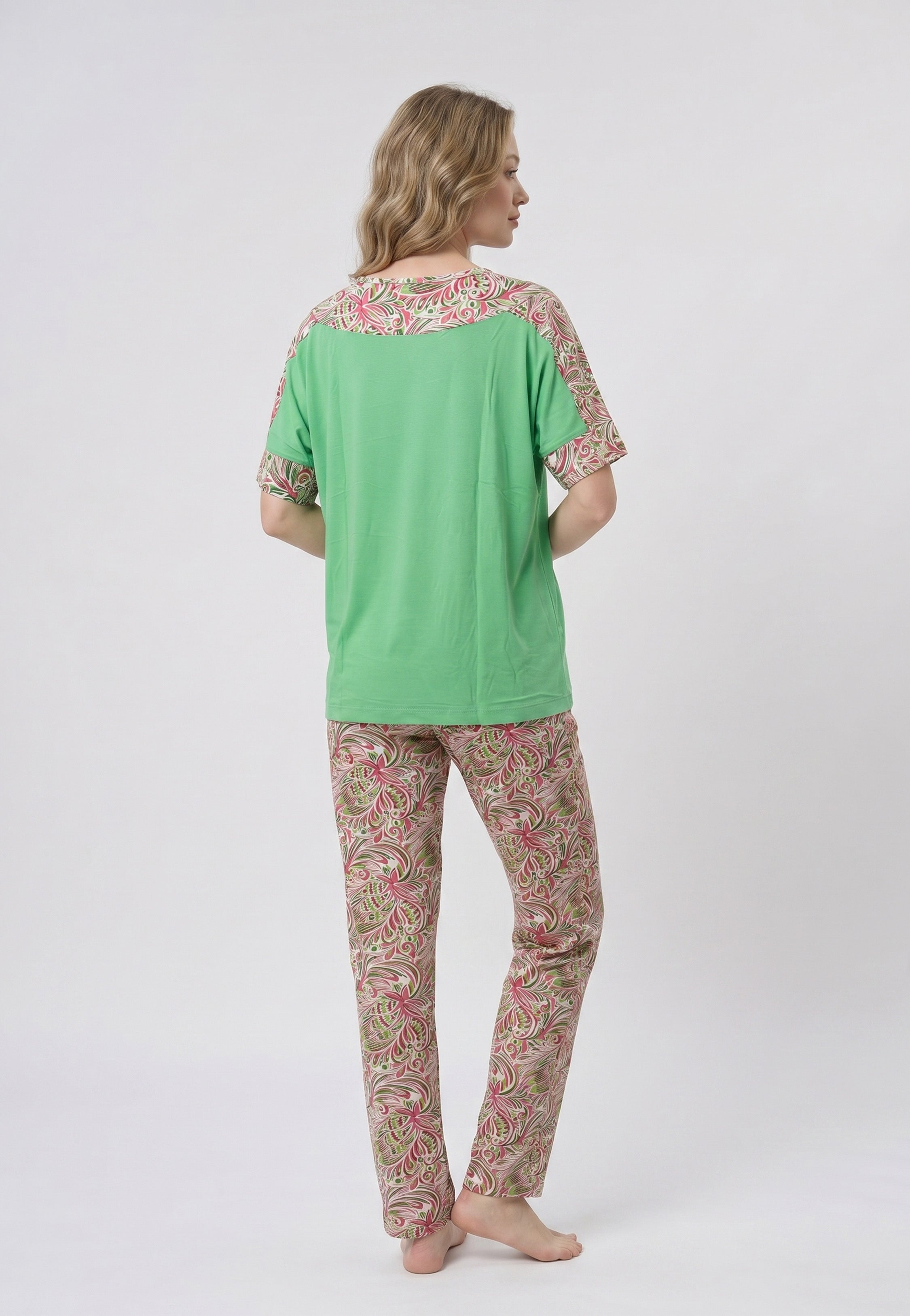 Femme portant un pyjama deux pièces t-shirt vert à empiècement fleuri et pantalon long imprimé ethnique floral multicolore sur fond gris Rosabella Ethnique 2