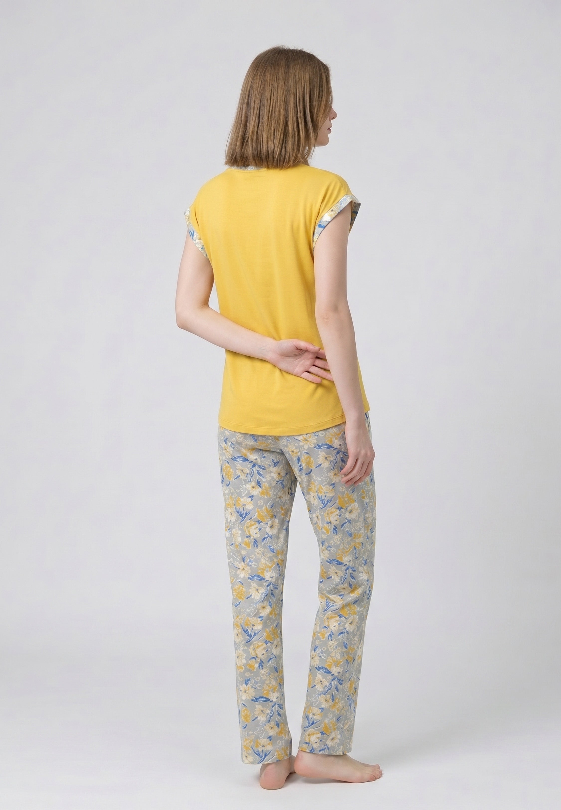 Femme portant un pyjama deux pièces t-shirt moutarde liseré fleuri au col et manches et pantalon long imprimé ethnique floral multicolore Rosabella Ethnique 2