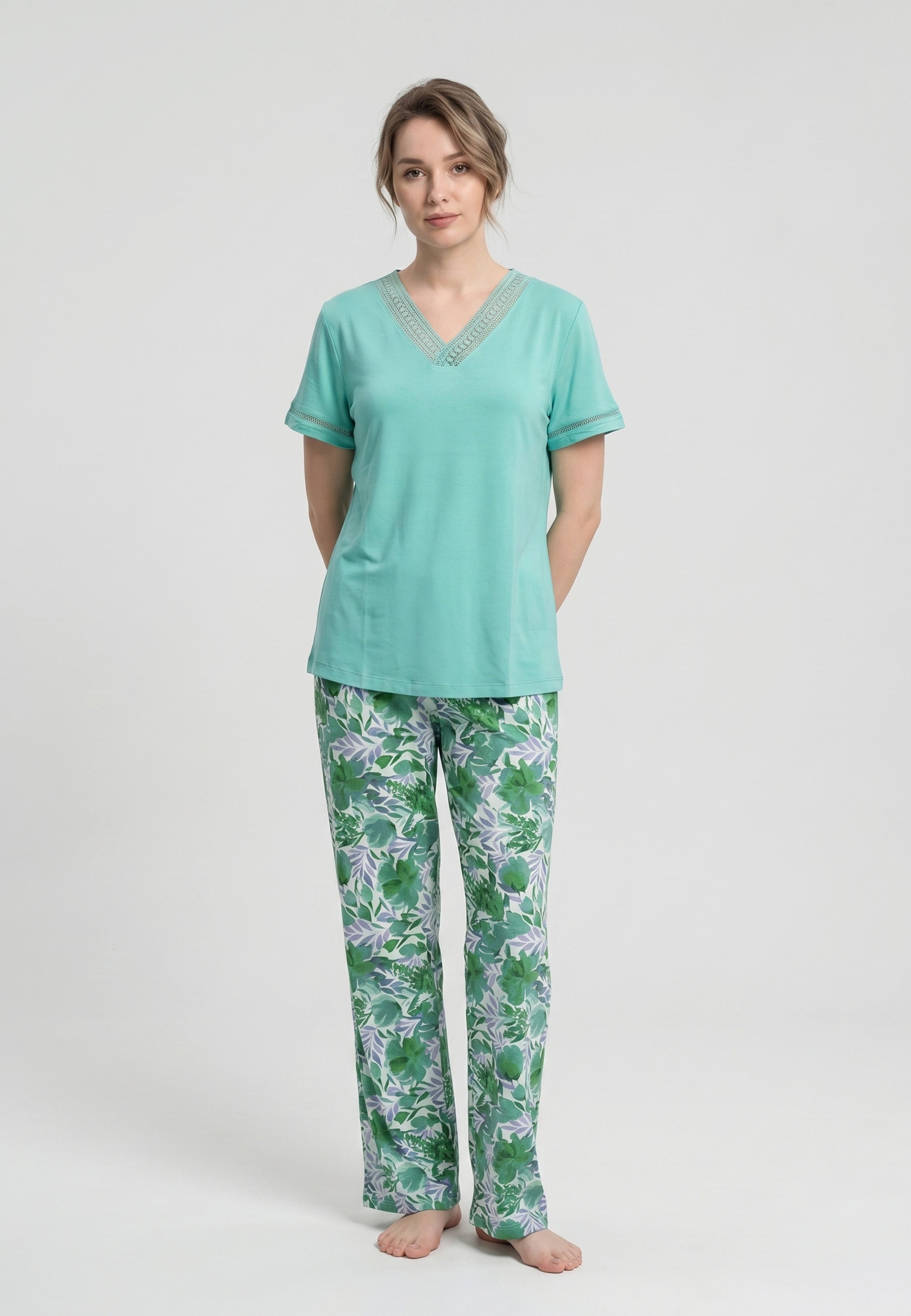 Femme portant un pyjama deux pièces t-shirt vert clair col V broderie anglaise et pantalon long imprimé feuillage botanique vert et lavande Rosabella Fleurs Sauvages