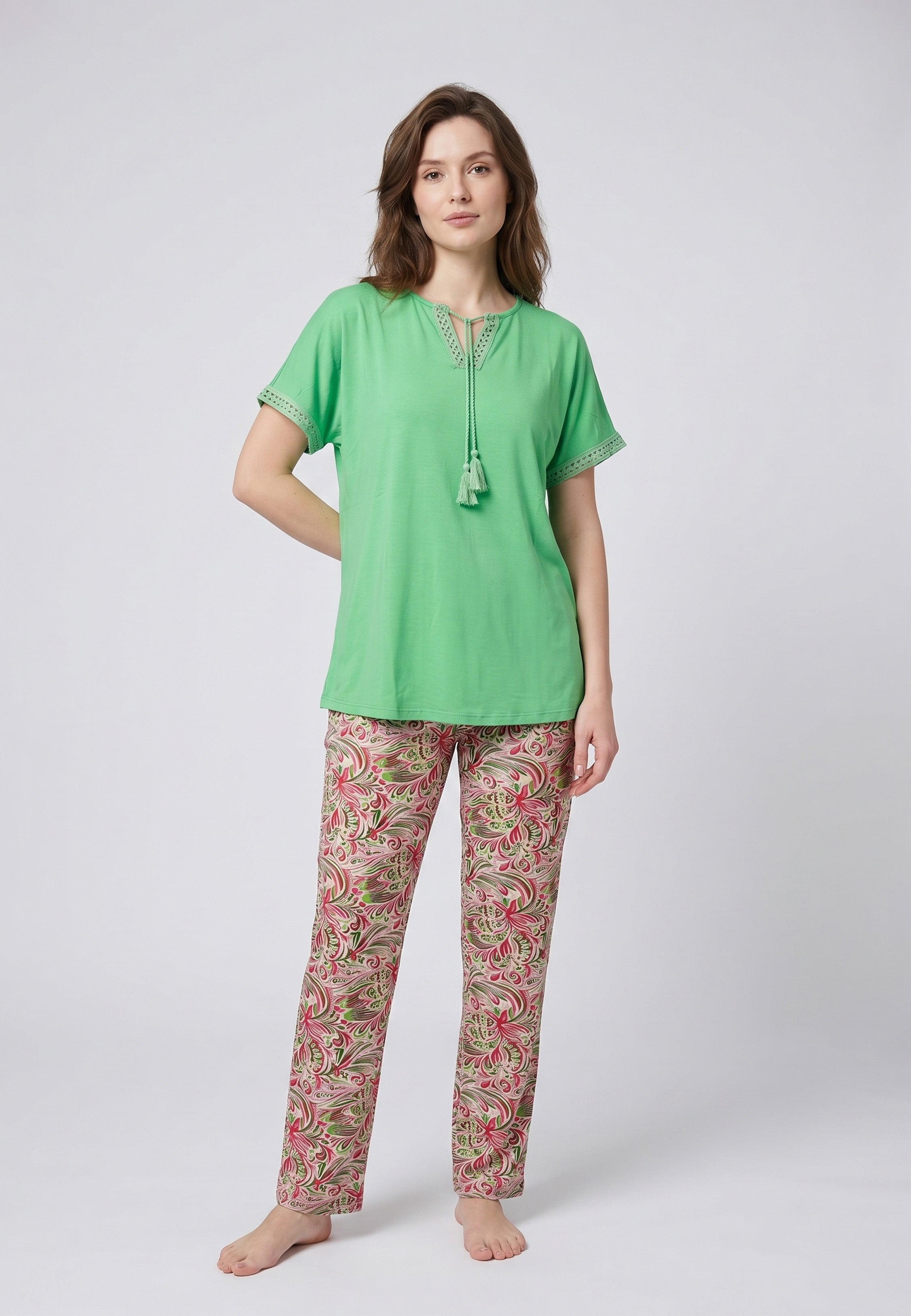Femme portant un pyjama deux pièces top vert broderie et lacets pompons au col et pantalon long imprimé ethnique floral multicolore Rosabella Ethnique 2