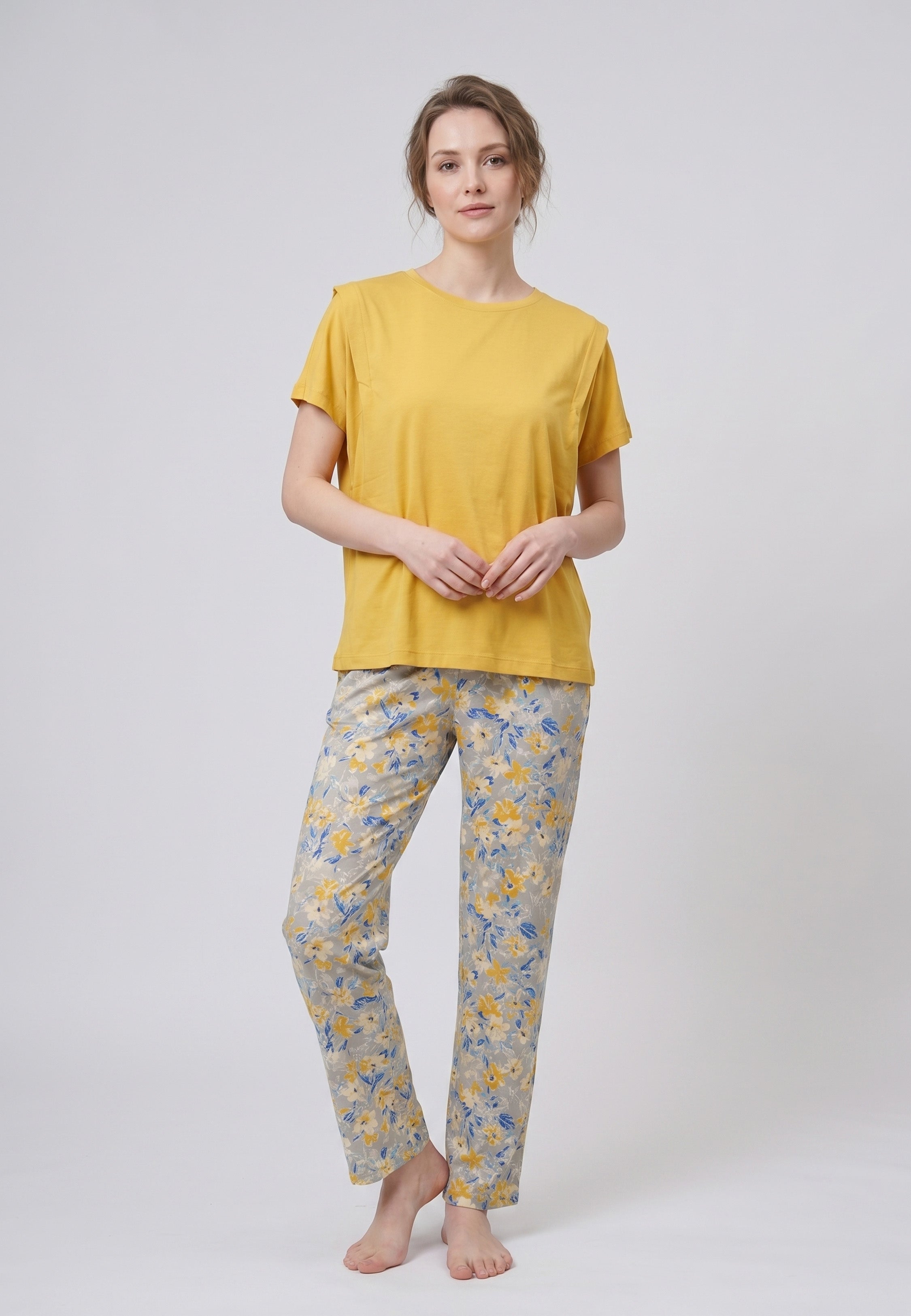 Femme portant un pyjama deux pièces t-shirt uni moutarde et pantalon long imprimé ethnique floral multicolore sur fond gris Rosabella Ethnique 2