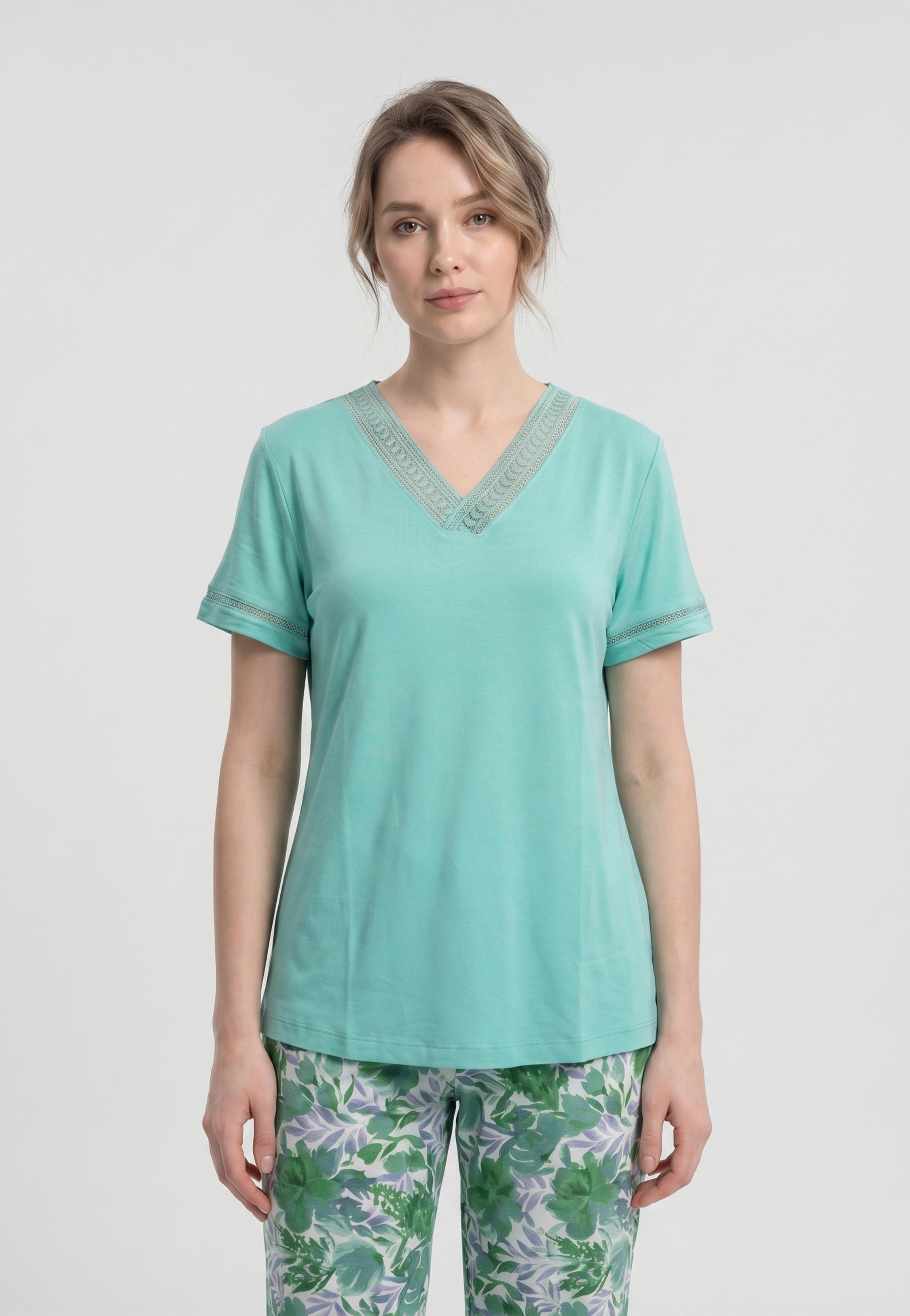 Femme portant un pyjama deux pièces t-shirt vert clair col V broderie anglaise et pantalon long imprimé feuillage botanique vert et lavande Rosabella Fleurs Sauvages