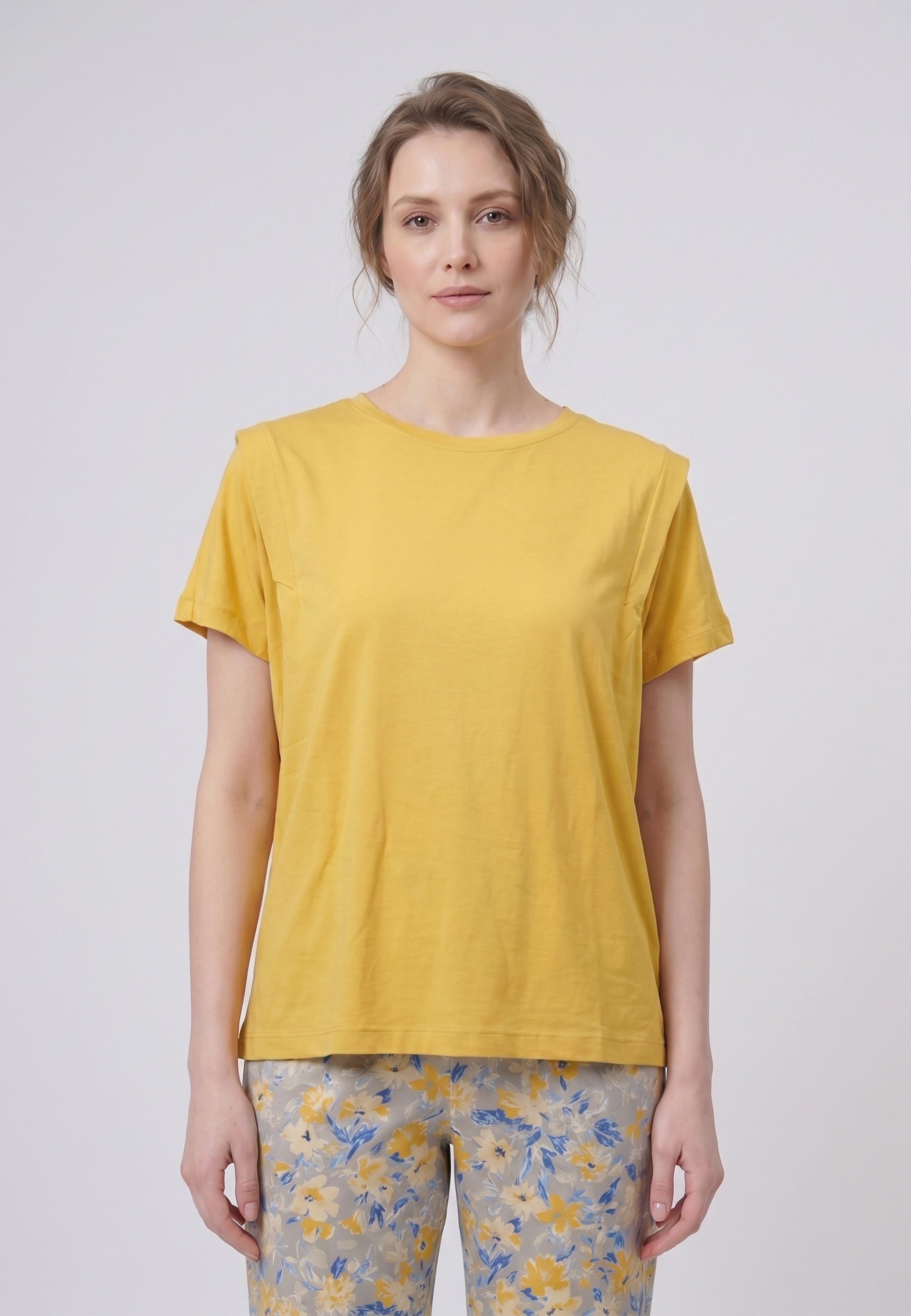 Femme portant un pyjama deux pièces t-shirt uni moutarde et pantalon long imprimé ethnique floral multicolore sur fond gris Rosabella Ethnique 2
