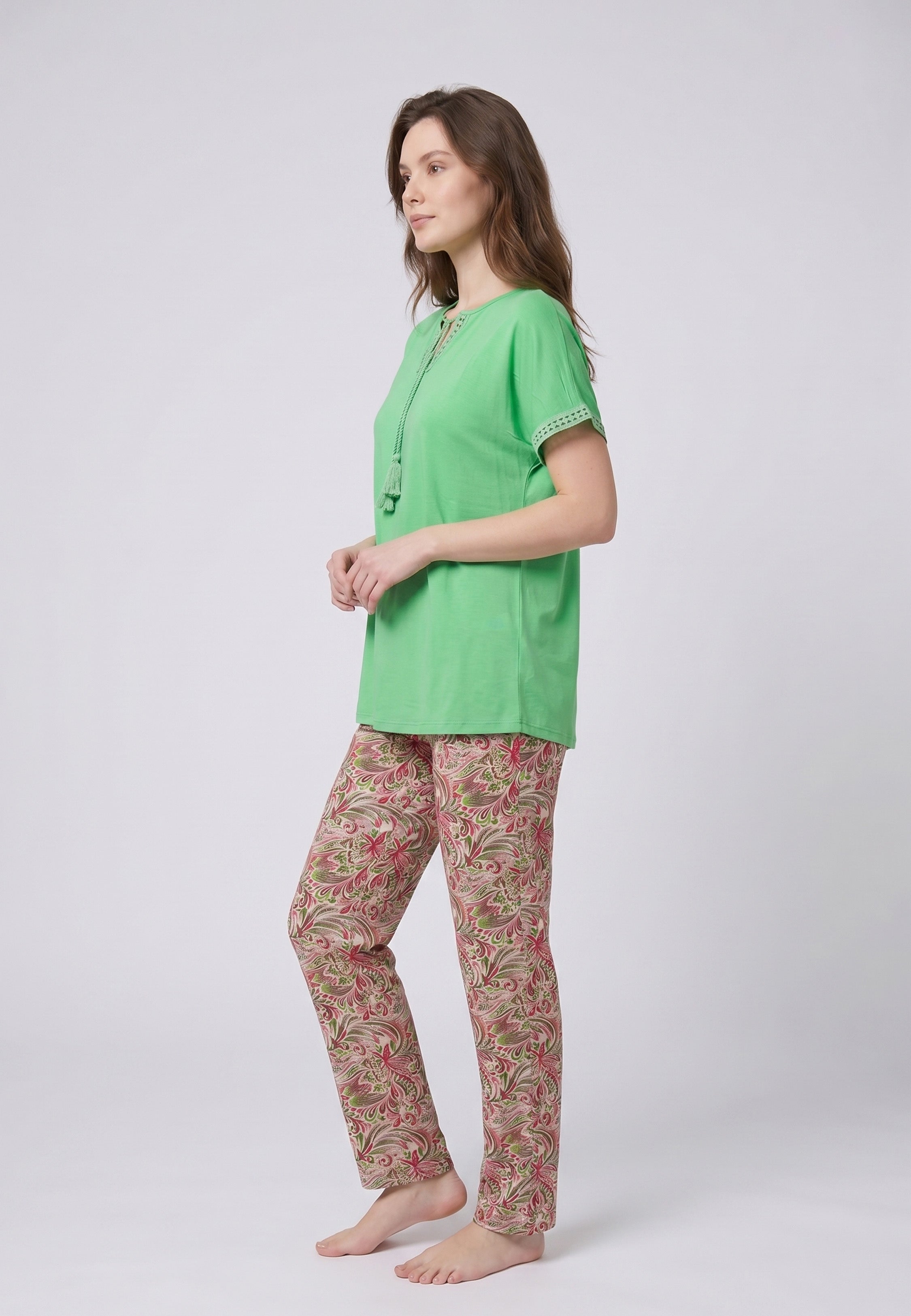 Femme portant un pyjama deux pièces top vert broderie et lacets pompons au col et pantalon long imprimé ethnique floral multicolore Rosabella Ethnique 2