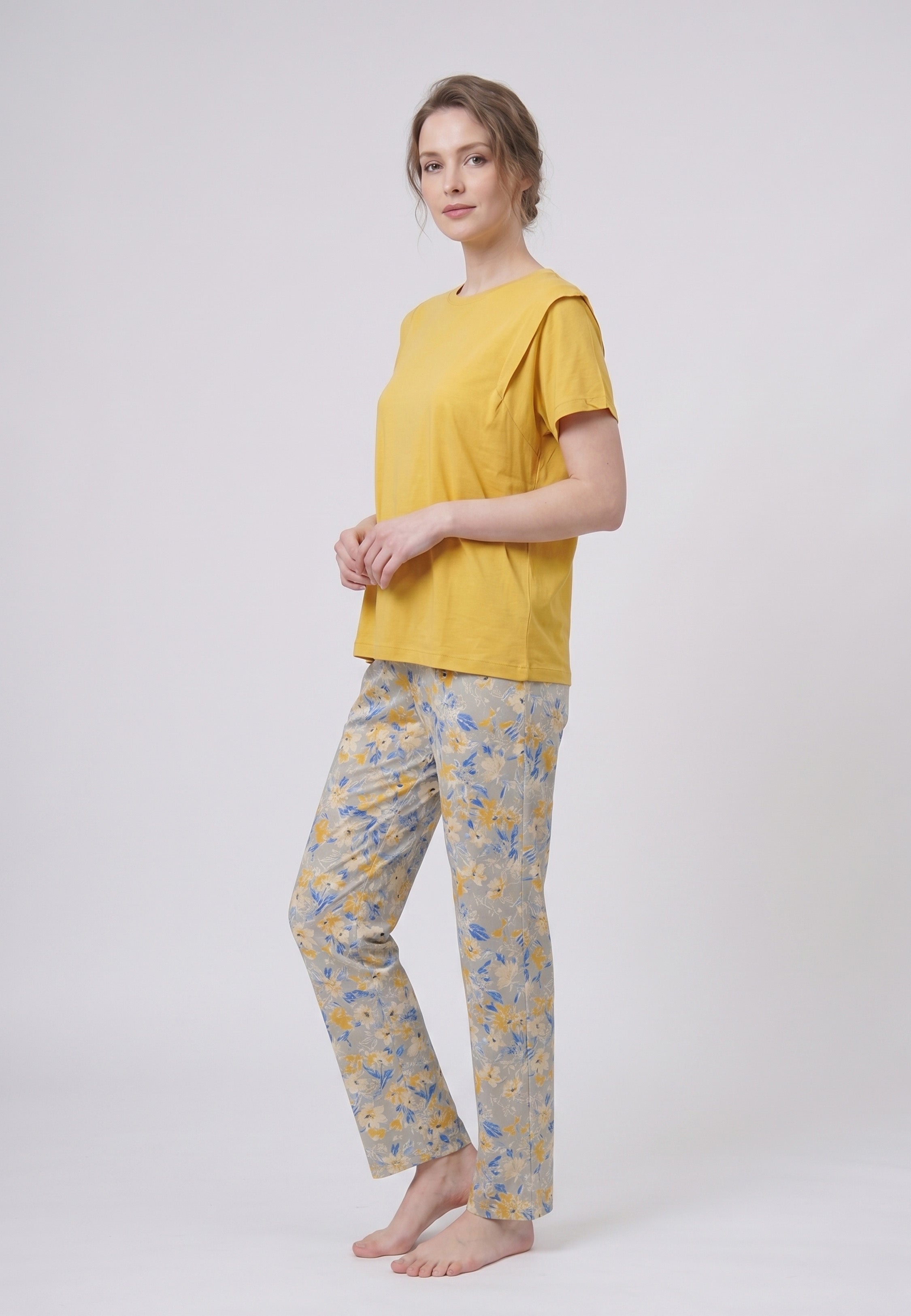 Femme portant un pyjama deux pièces t-shirt uni moutarde et pantalon long imprimé ethnique floral multicolore sur fond gris Rosabella Ethnique 2