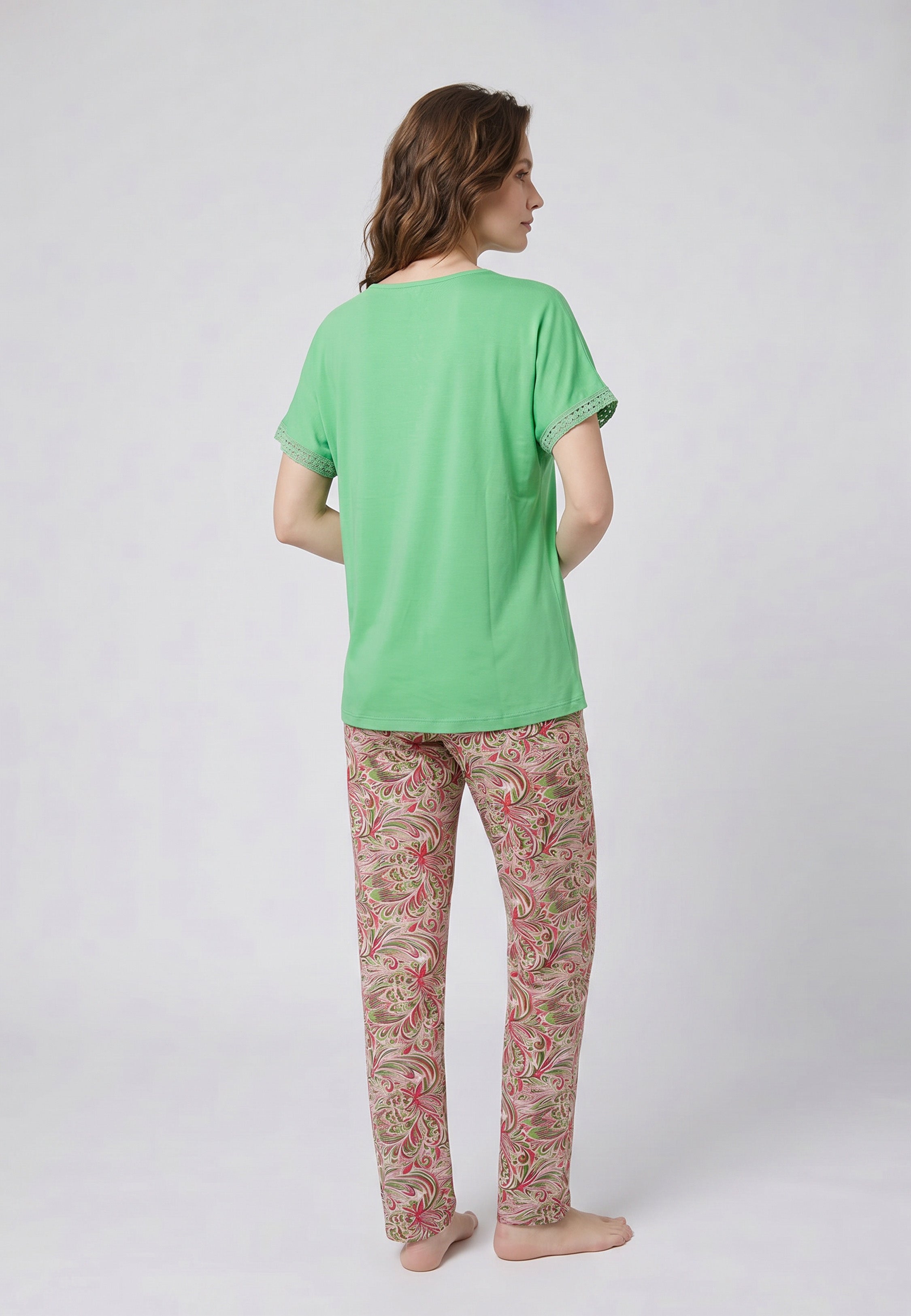 Femme portant un pyjama deux pièces top vert broderie et lacets pompons au col et pantalon long imprimé ethnique floral multicolore Rosabella Ethnique 2