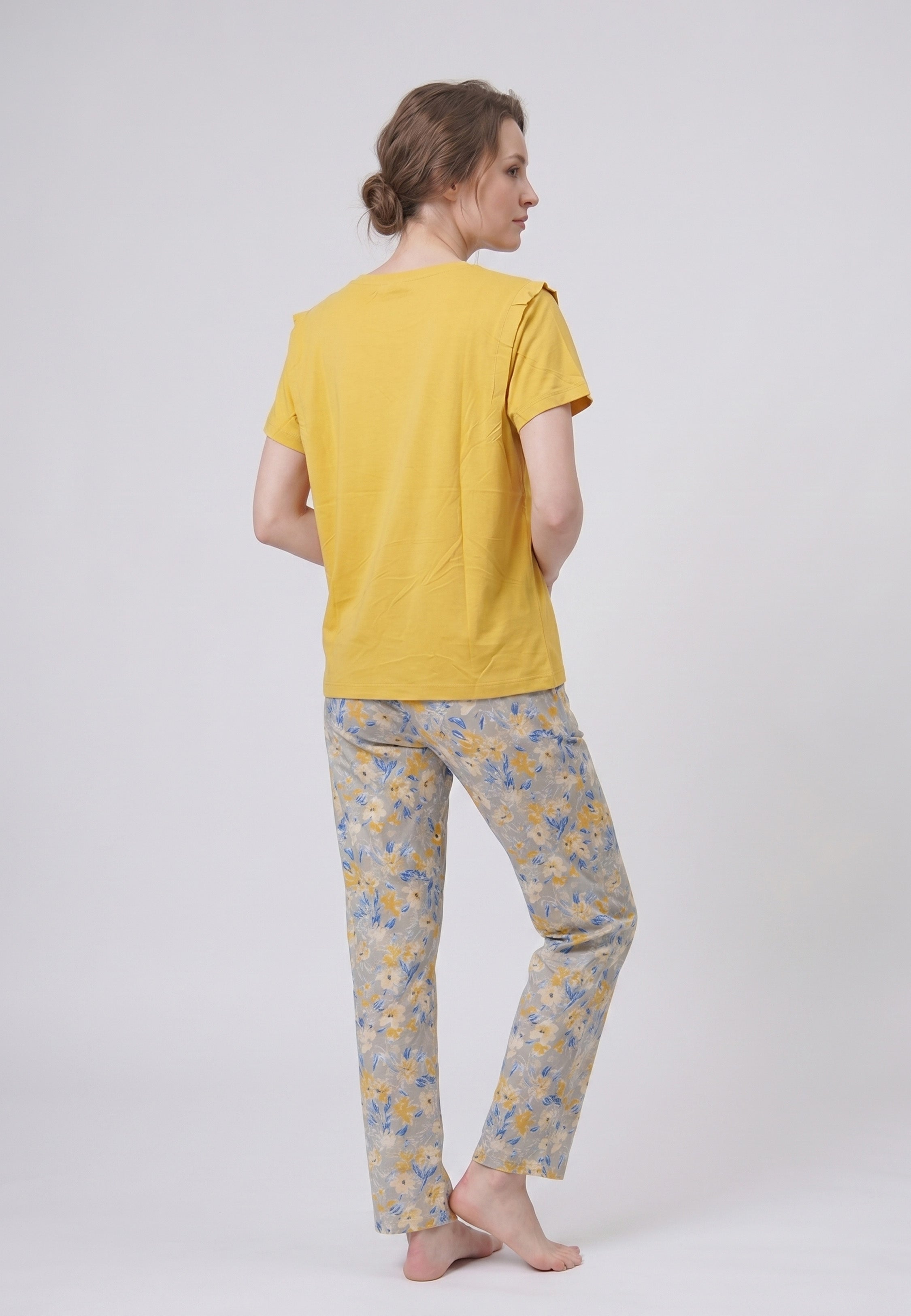 Femme portant un pyjama deux pièces t-shirt uni moutarde et pantalon long imprimé ethnique floral multicolore sur fond gris Rosabella Ethnique 2