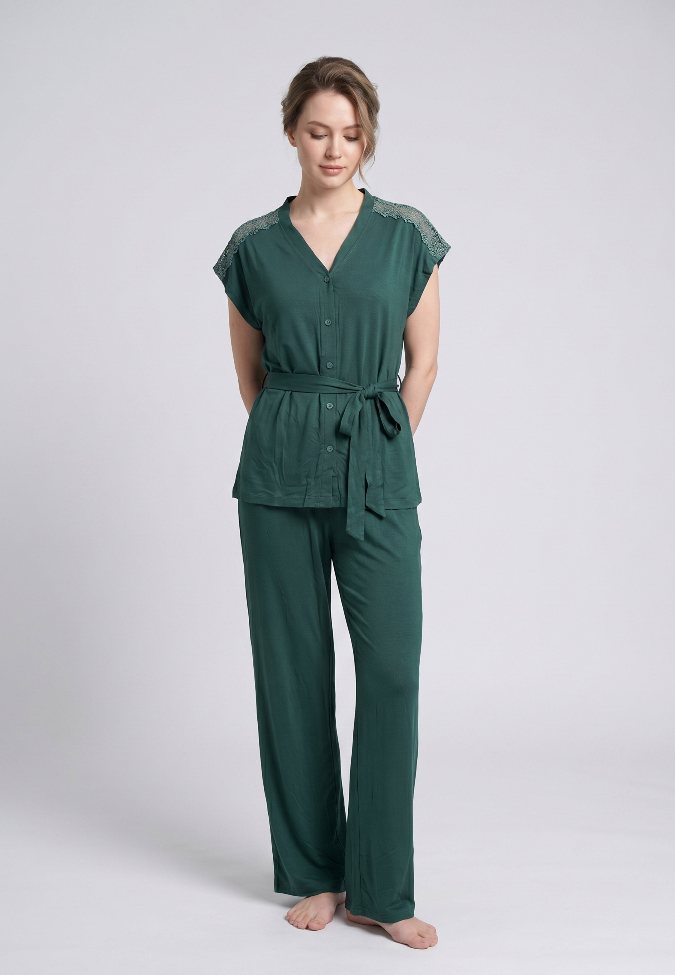 Femme portant un pyjama deux pièces top col V boutonnée broderie épaules ceinture lacet uni vert et pantalon long uni Rosabella Cozy Comforts