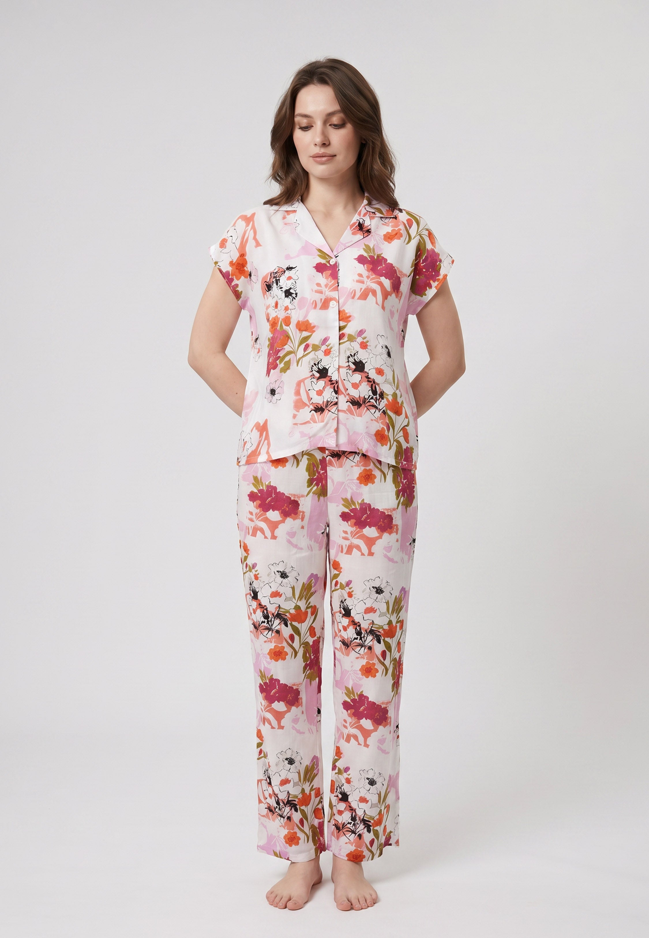 Femme portant un pyjama deux pièces chemise boutonnée col revers imprimé fleuri multicolore orange et pantalon long assorti Rosabella Chic Line