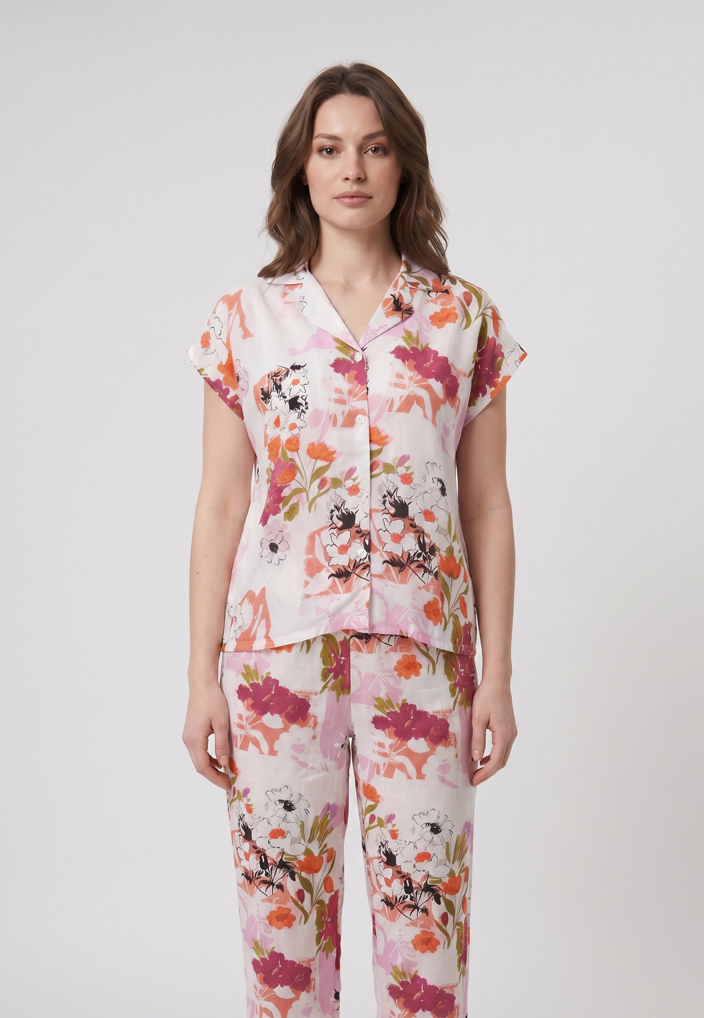 Femme portant un pyjama deux pièces chemise boutonnée col revers imprimé fleuri multicolore orange et pantalon long assorti Rosabella Chic Line