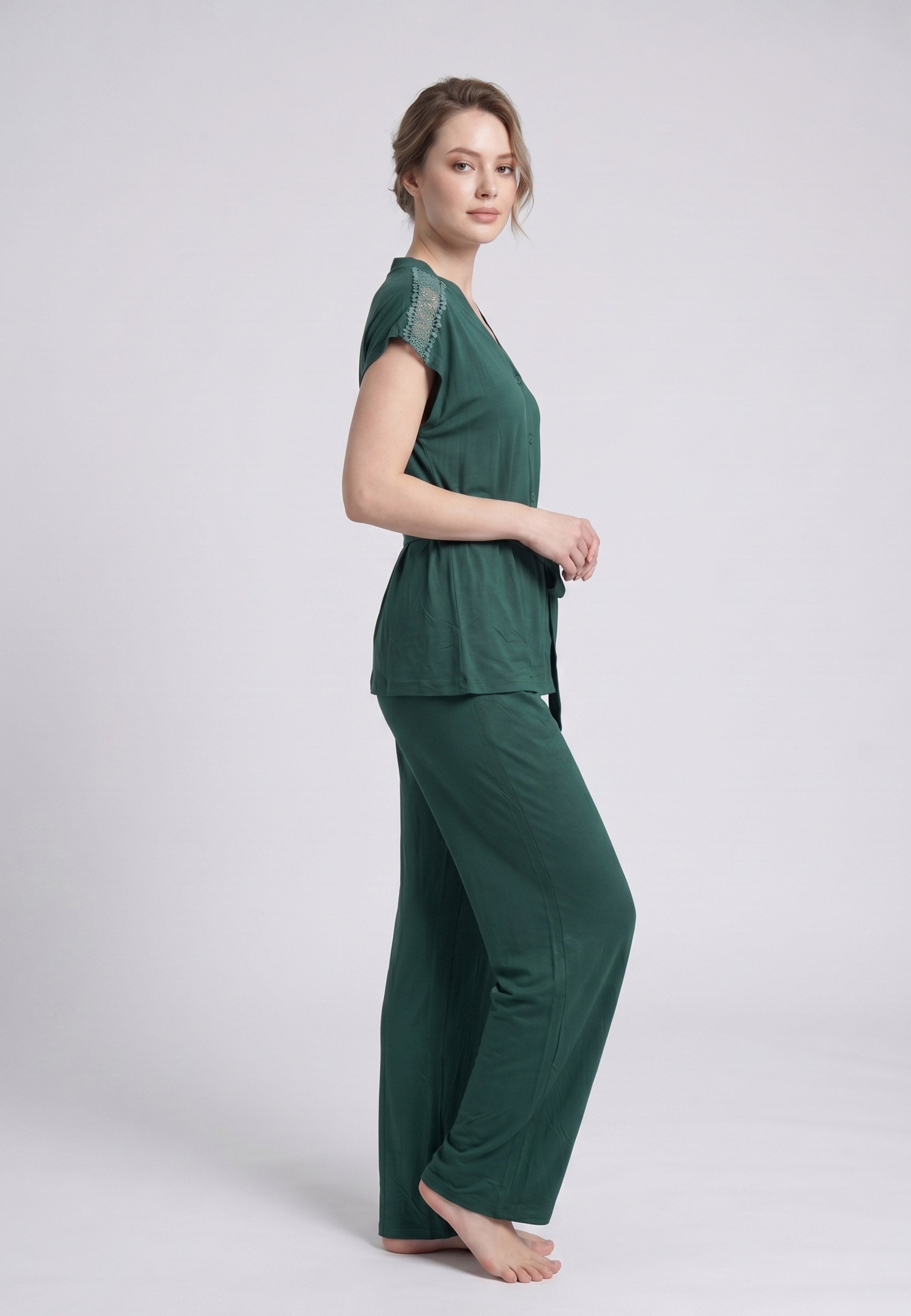 Femme portant un pyjama deux pièces top col V boutonnée broderie épaules ceinture lacet uni vert et pantalon long uni Rosabella Cozy Comforts