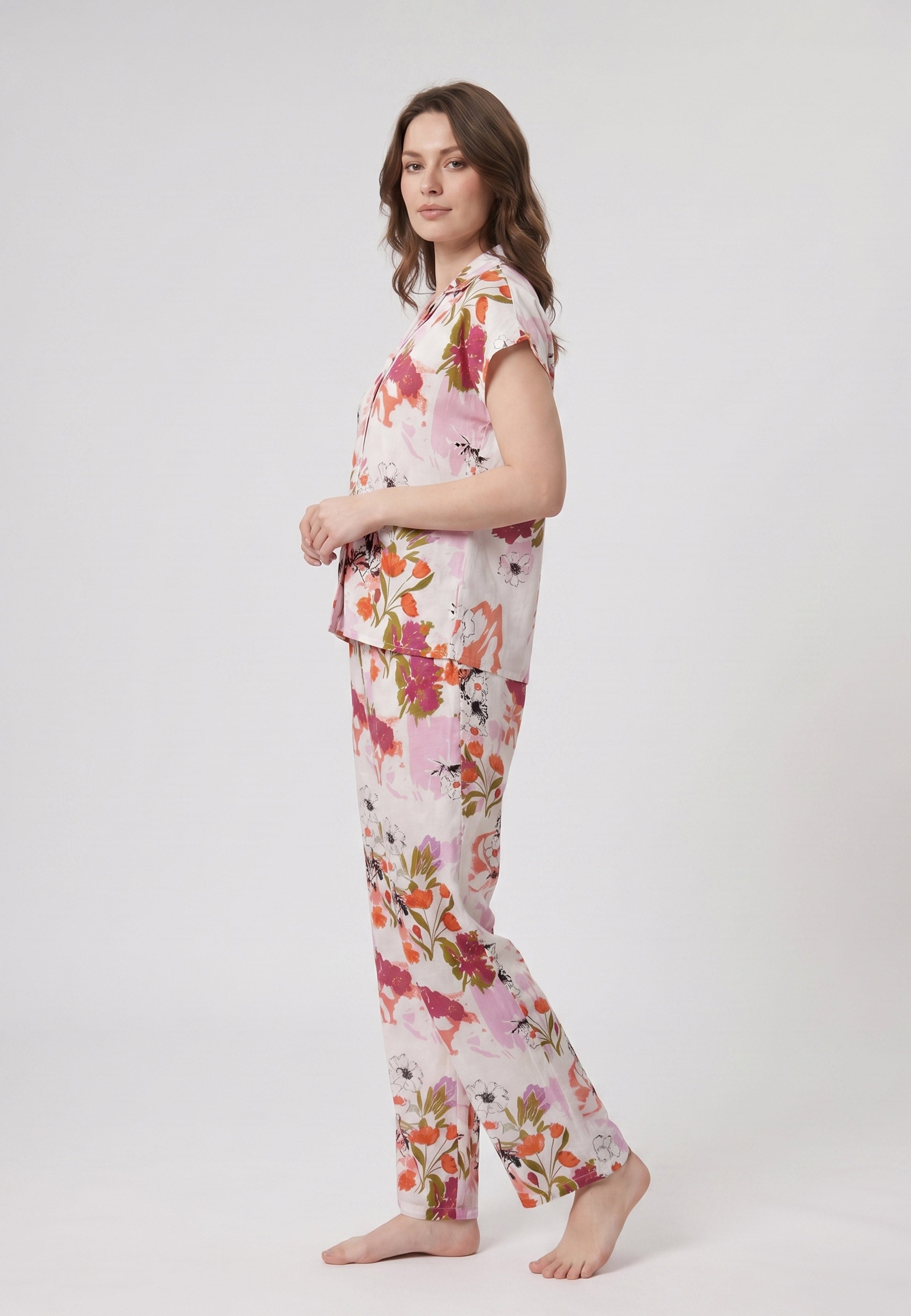 Femme portant un pyjama deux pièces chemise boutonnée col revers imprimé fleuri multicolore orange et pantalon long assorti Rosabella Chic Line