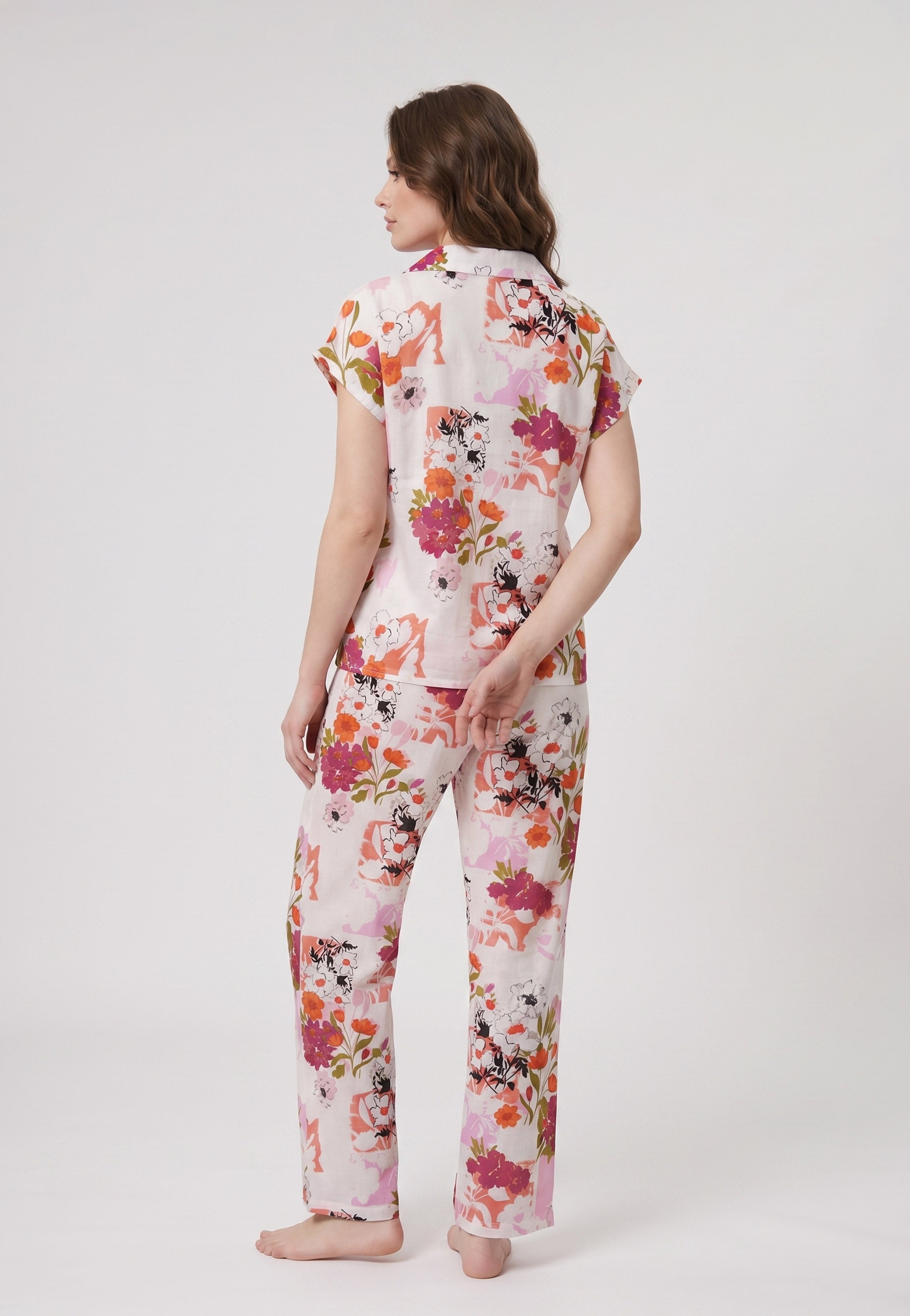 Femme portant un pyjama deux pièces chemise boutonnée col revers imprimé fleuri multicolore orange et pantalon long assorti Rosabella Chic Line