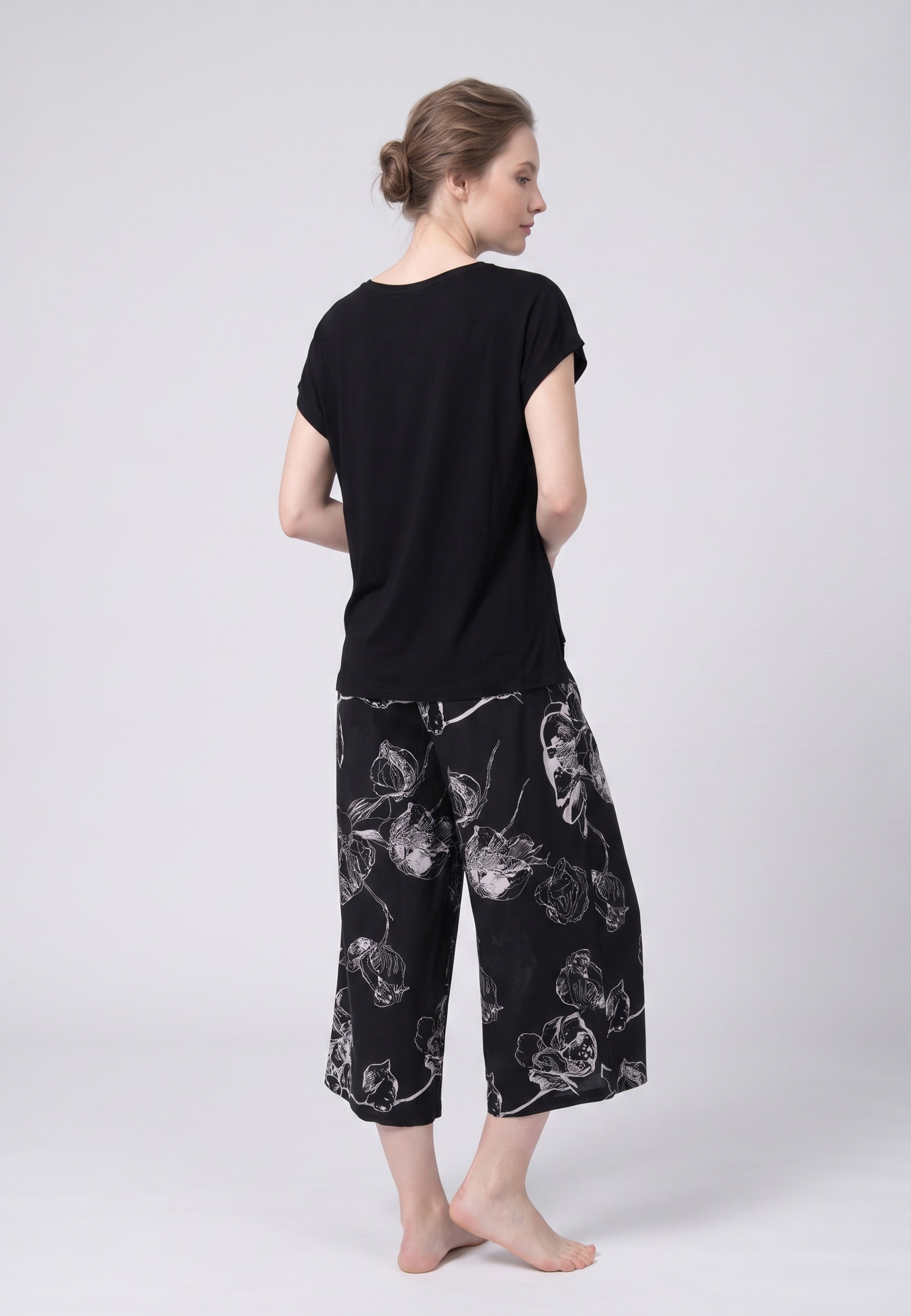 Femme portant un t-shirt noir & pantacourt grandes fleurs écru Rosabella
