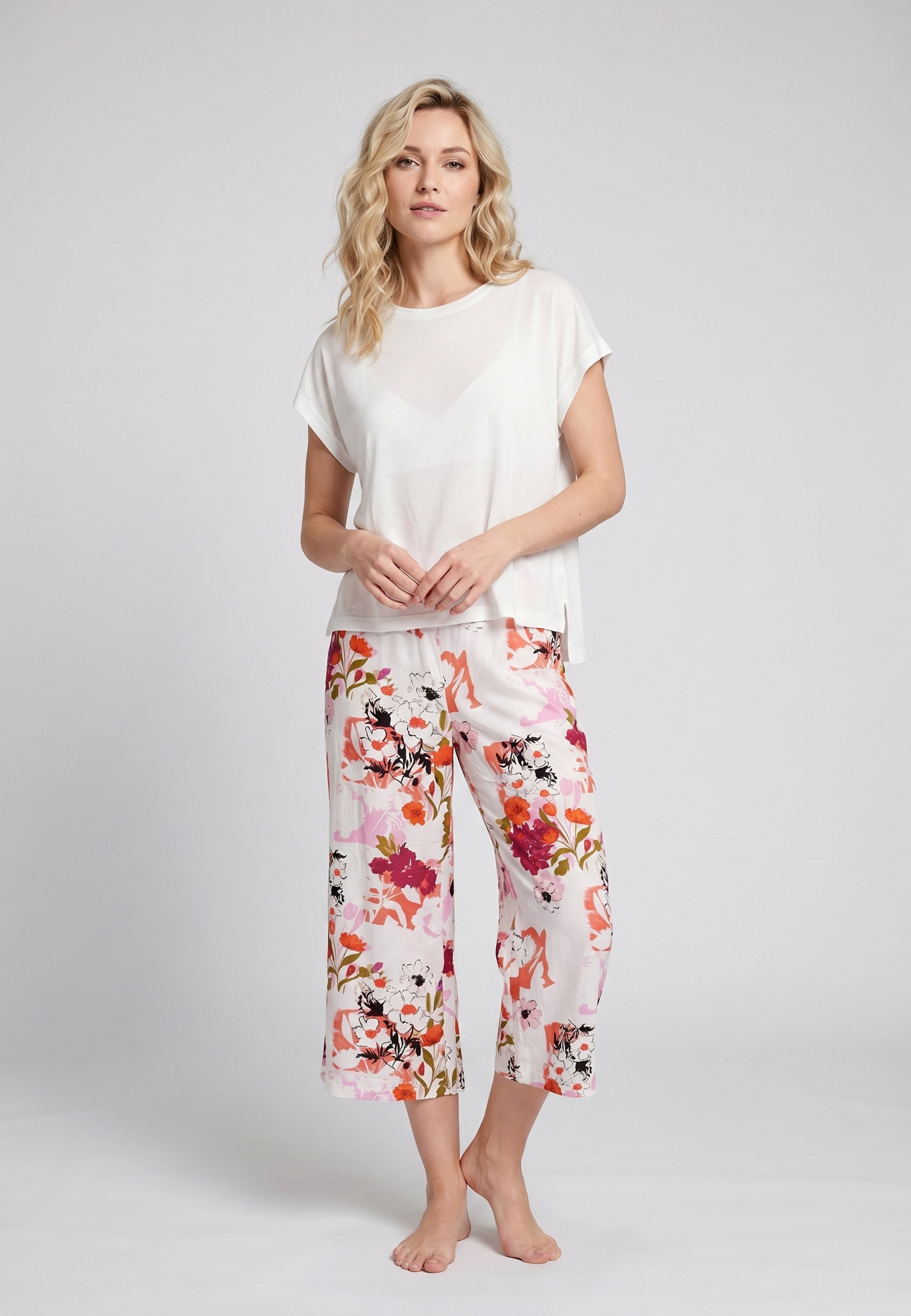 Femme portant un pyjama deux pièces t-shirt oversize uni blanc et pantacourt large imprimé fleuri multicolore orange Rosabella Chic Line
