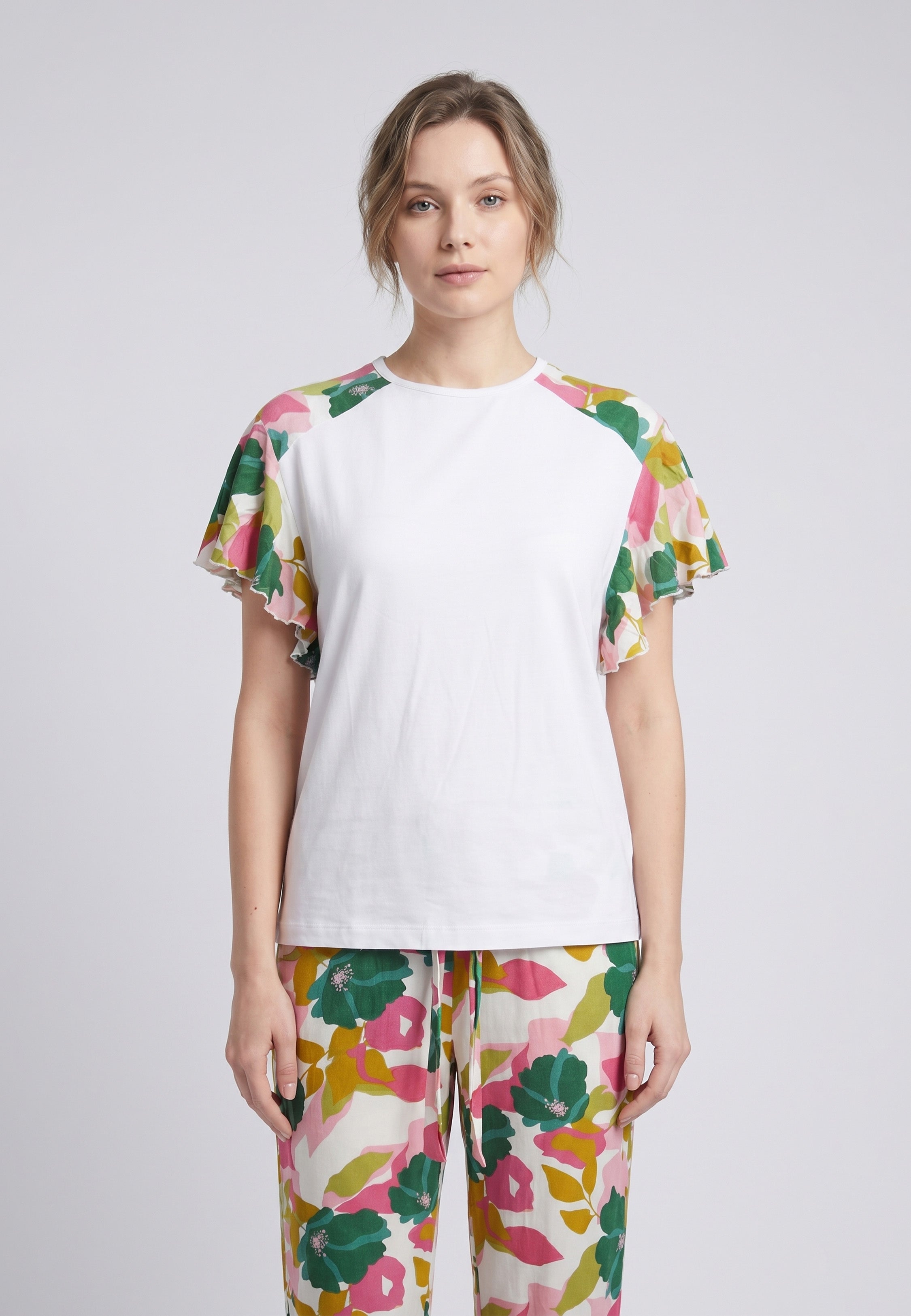 Femme portant un pyjama deux pièces t-shirt blanc manches volantées à imprimé fleuri et pantalon long grand imprimé fleuri multicolore Rosabella Rosalinda 2