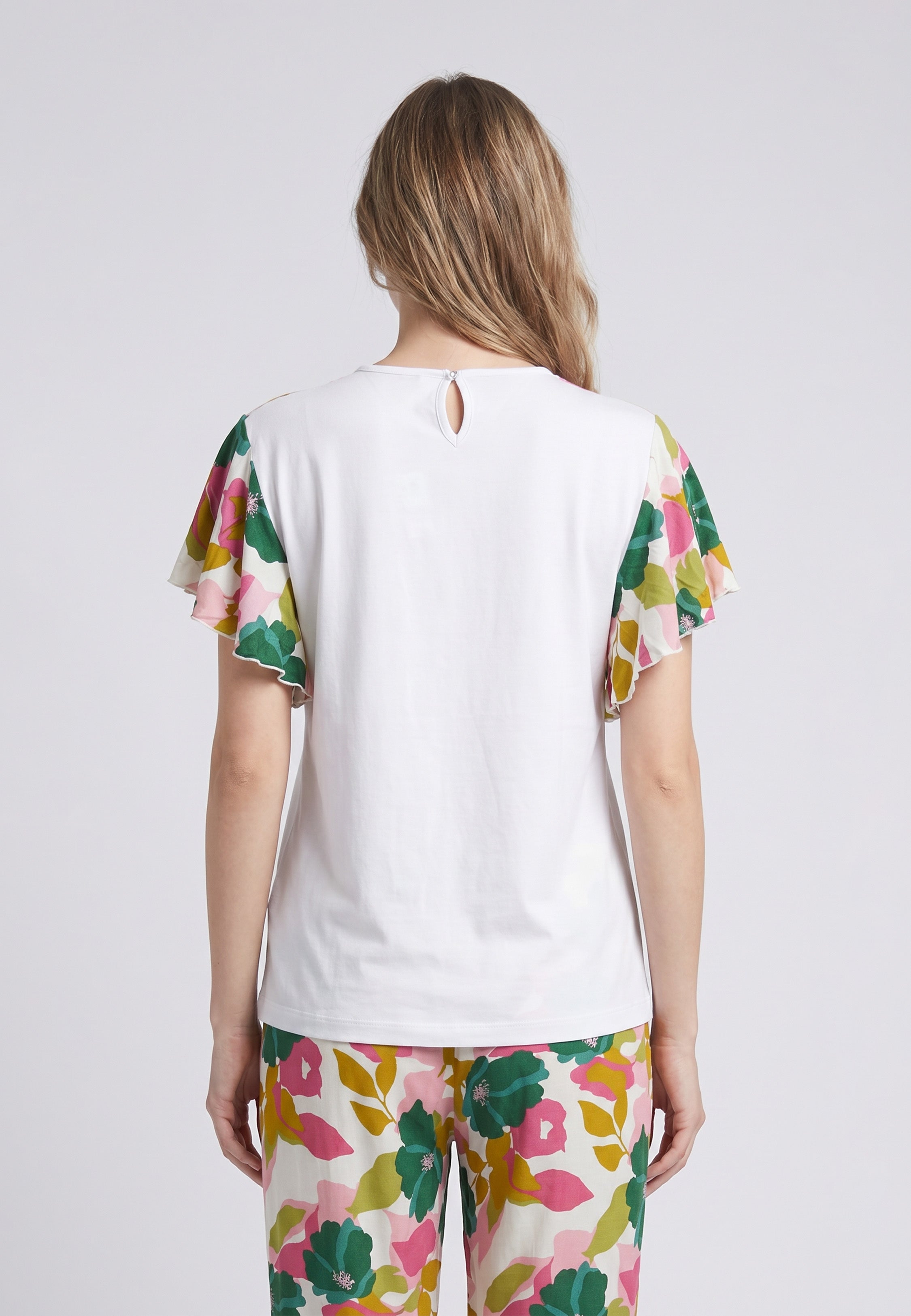 Femme portant un pyjama deux pièces t-shirt blanc manches volantées à imprimé fleuri et pantalon long grand imprimé fleuri multicolore Rosabella Rosalinda 2