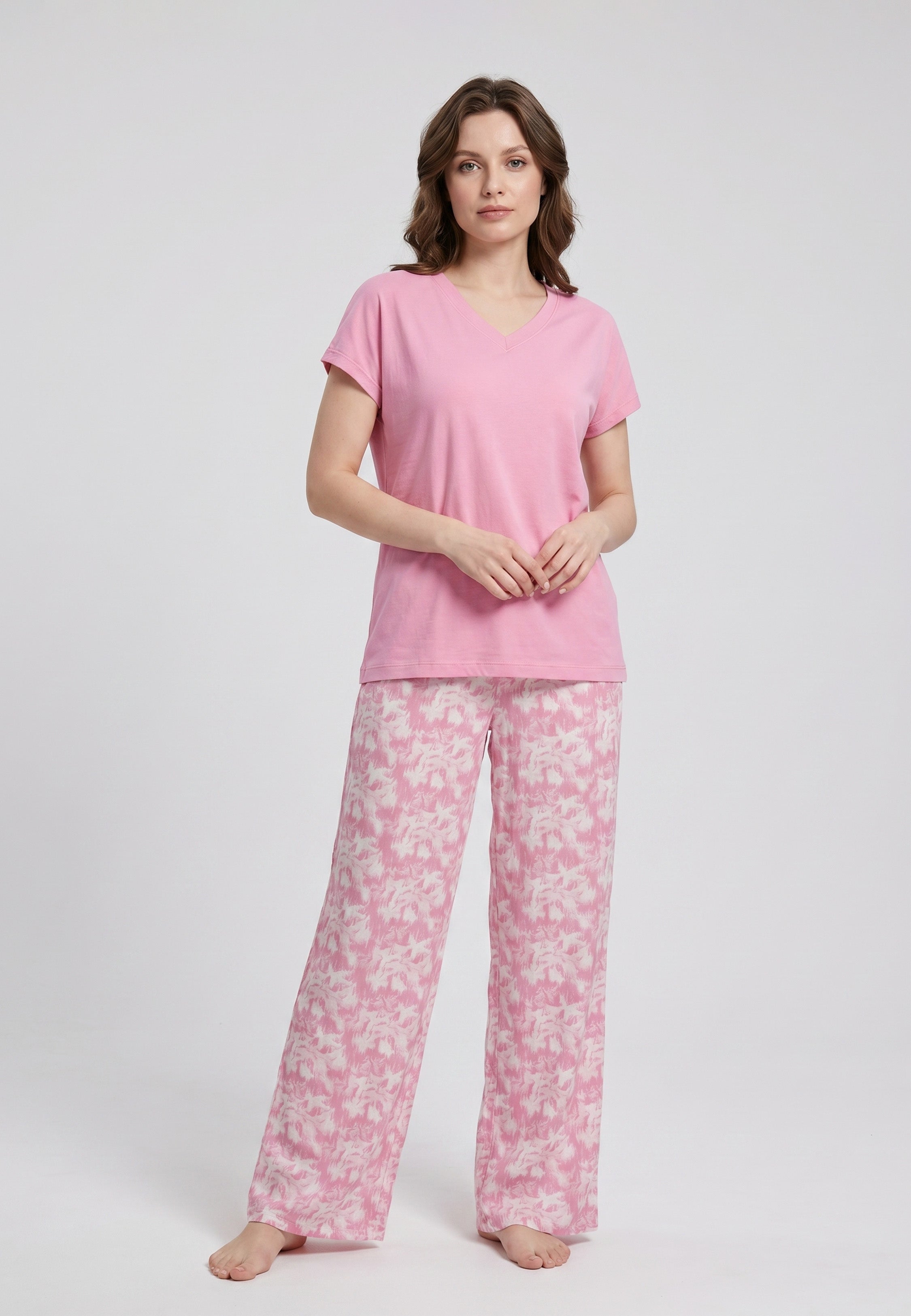 Femme portant un pyjama deux pièces t-shirt col V rose uni et pantalon large imprimé aquarelle rose et blanc Rosabella Mellow Moments