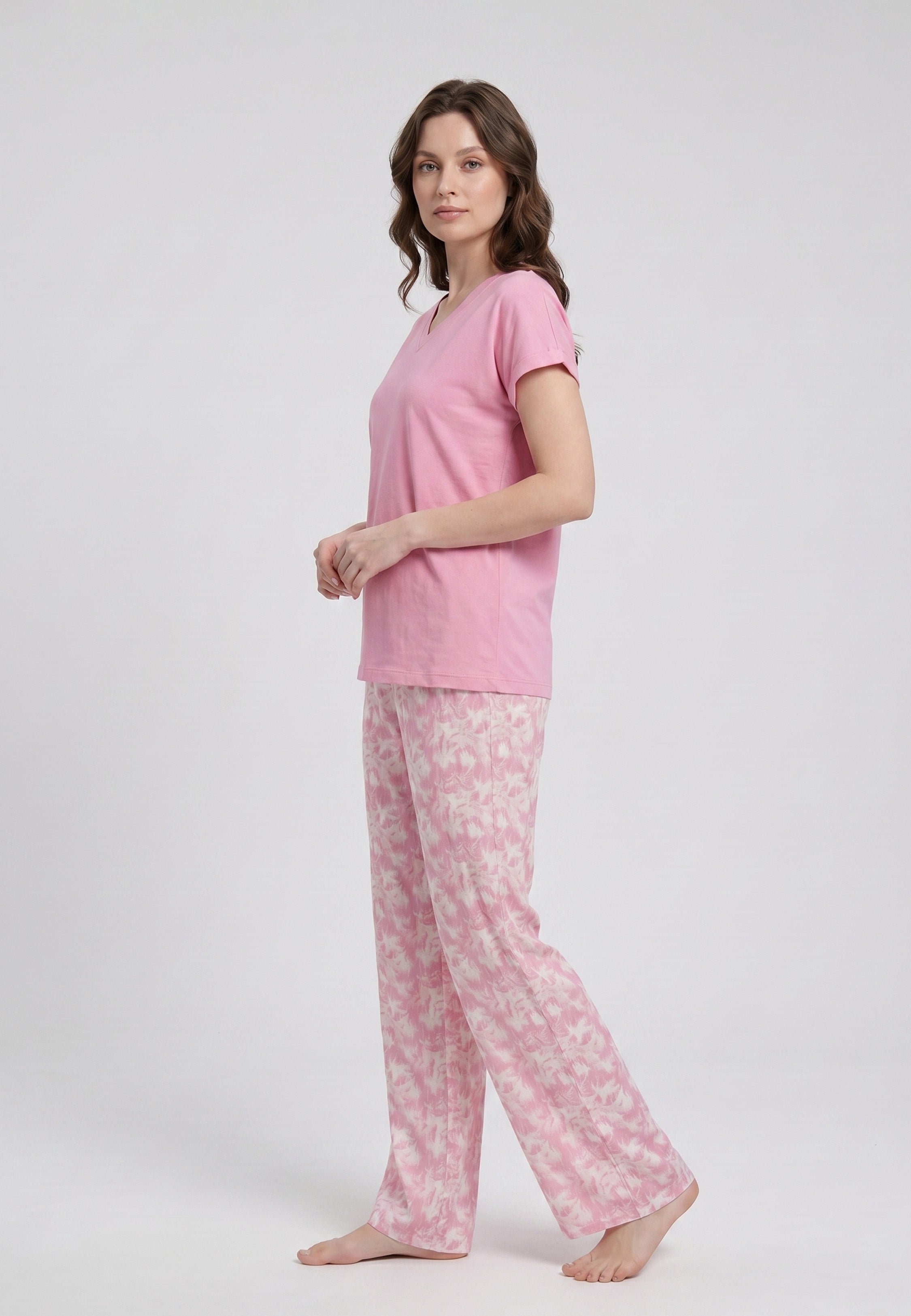 Femme portant un pyjama deux pièces t-shirt col V rose uni et pantalon large imprimé aquarelle rose et blanc Rosabella Mellow Moments