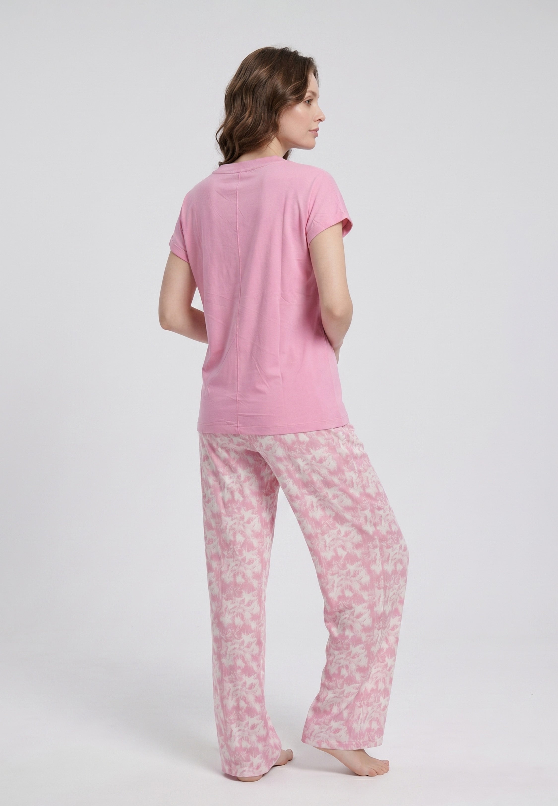 Femme portant un pyjama deux pièces t-shirt col V rose uni et pantalon large imprimé aquarelle rose et blanc Rosabella Mellow Moments