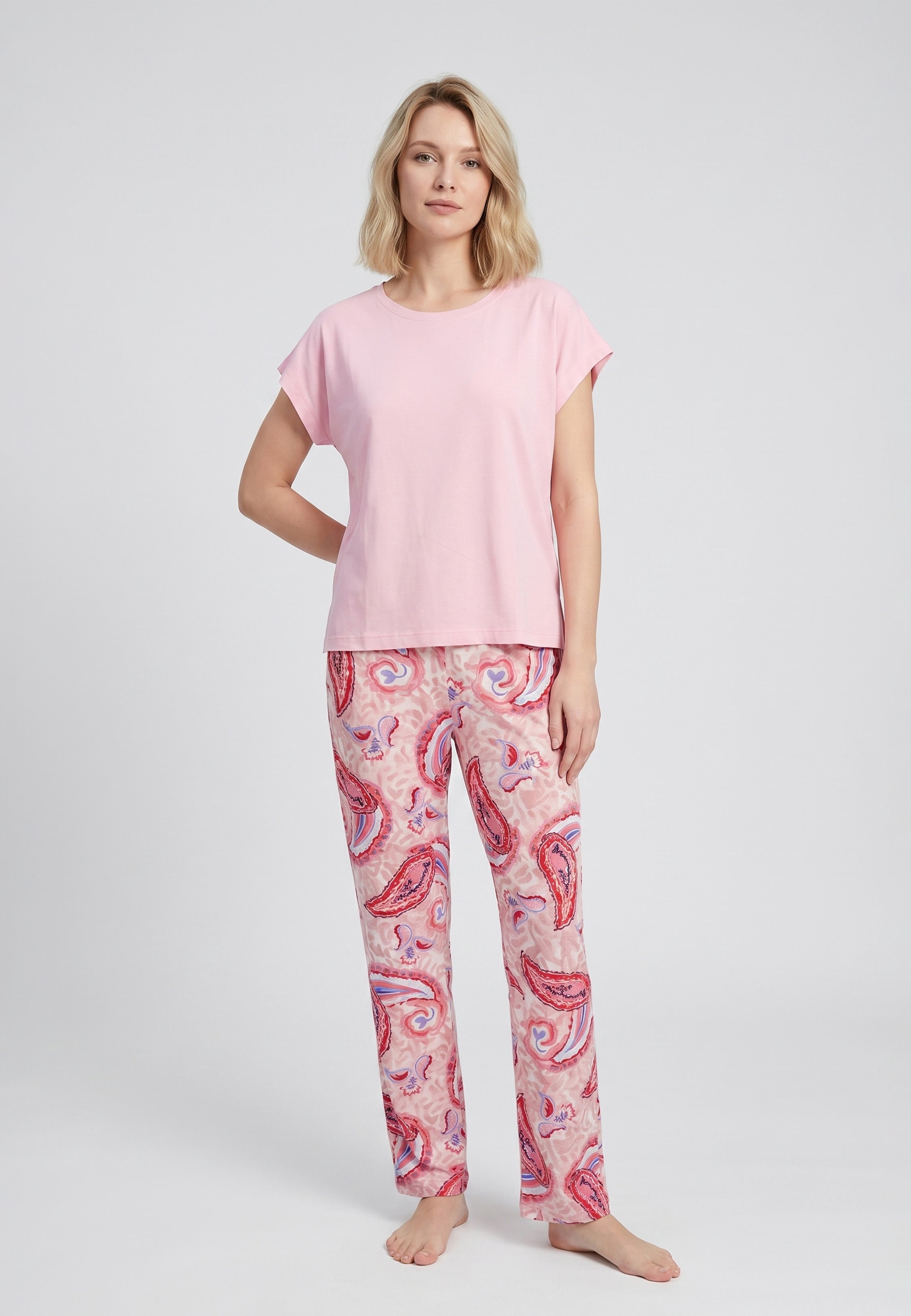 Femme portant un pyjama deux pièces t-shirt oversize col rond uni rose et pantalon droit imprimé paisley multicolore rose et rouge Rosabella Ethnique 2