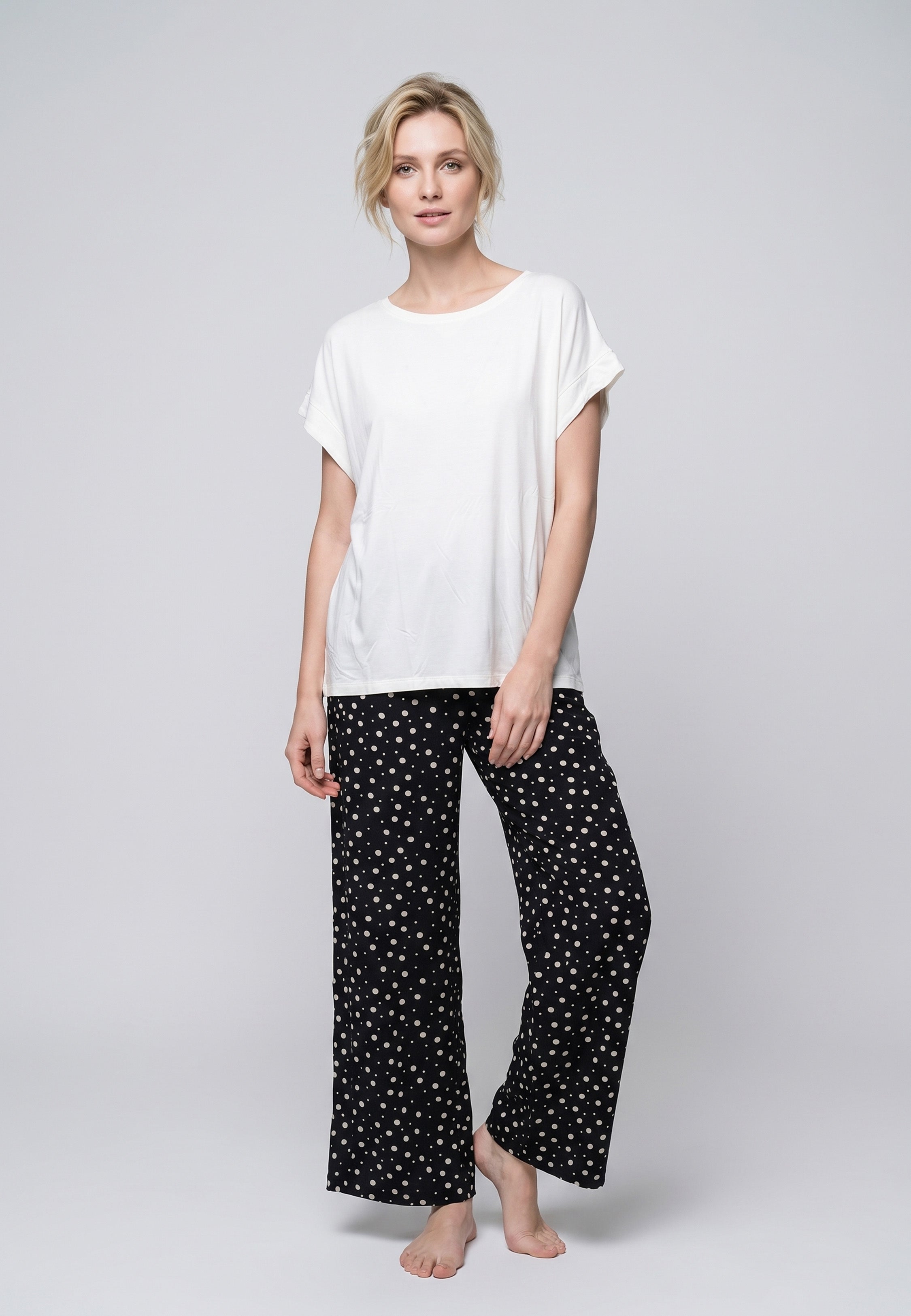 Femme portant un t-shirt écru & pantalon large imprimé pois crème Rosabella
