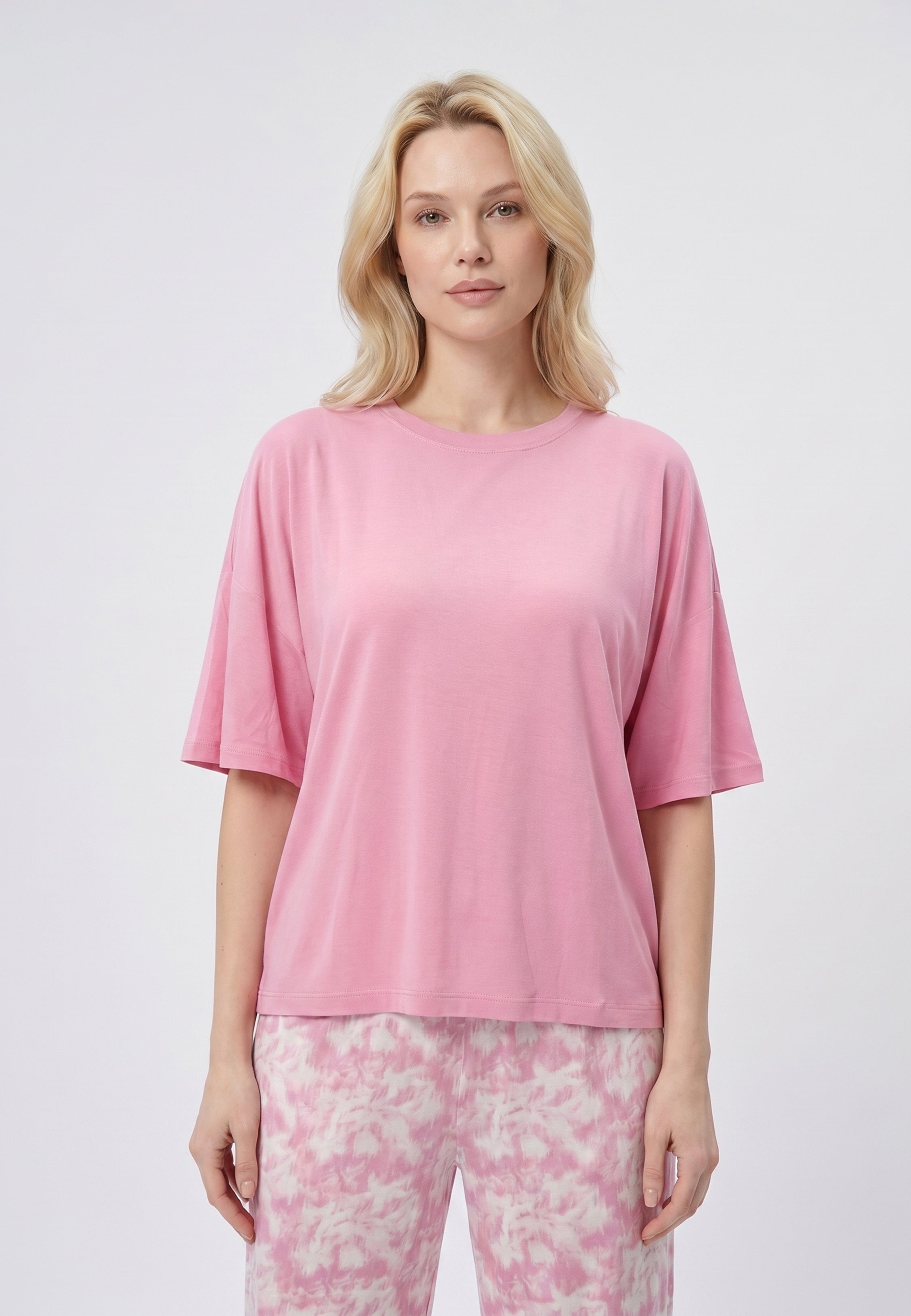 Femme portant un pyjama deux pièces t-shirt oversize rose uni et pantalon large imprimé aquarelle rose et blanc Rosabella Mellow Moments