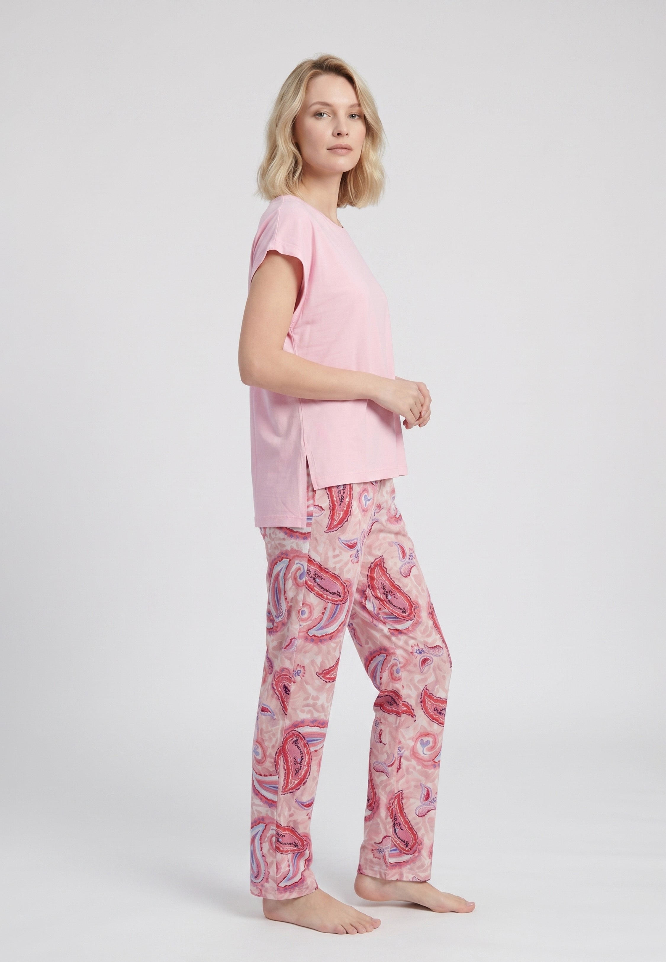 Femme portant un pyjama deux pièces t-shirt oversize col rond uni rose et pantalon droit imprimé paisley multicolore rose et rouge Rosabella Ethnique 2