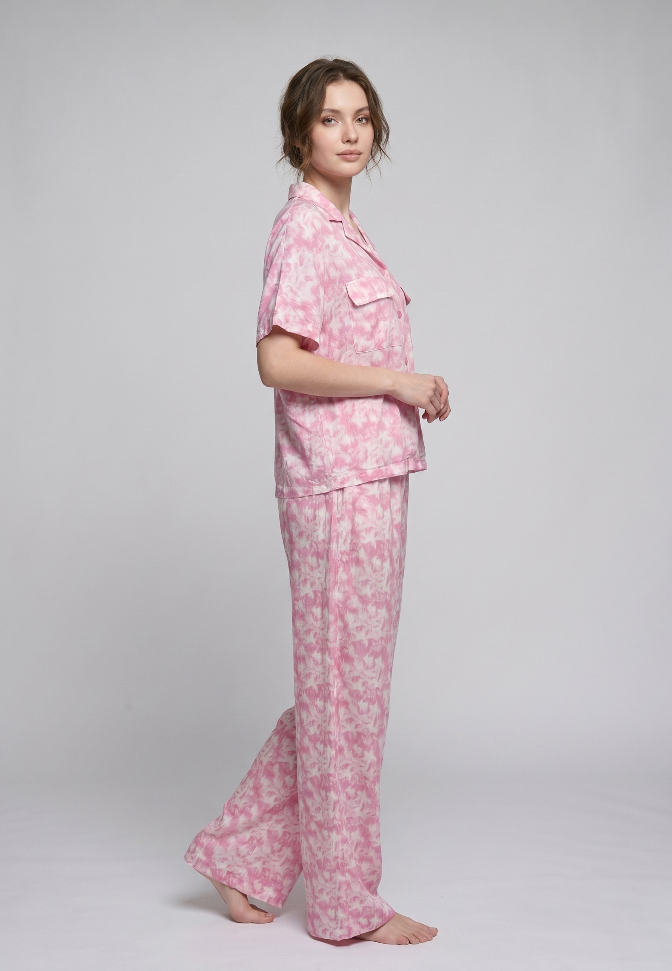Femme portant un pyjama deux pièces chemise boutonnée manches courtes et pantalon large imprimé aquarelle rose clair et blanc Rosabella Aurora Line