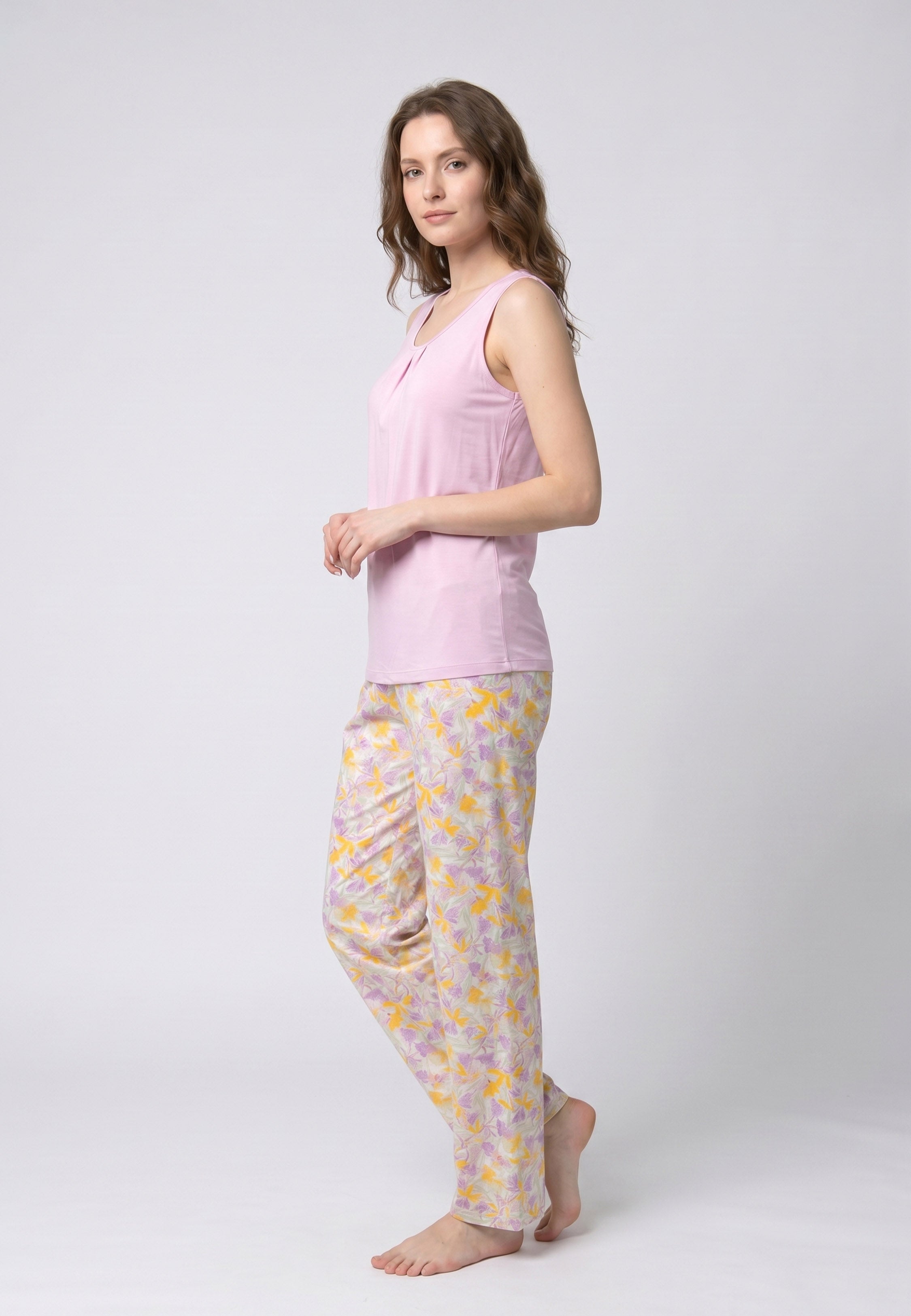 Femme portant un pyjama deux pièces débardeur col rond froncé uni mauve et pantalon long imprimé fleuri jaune mauve et vert Rosabella Chic Line