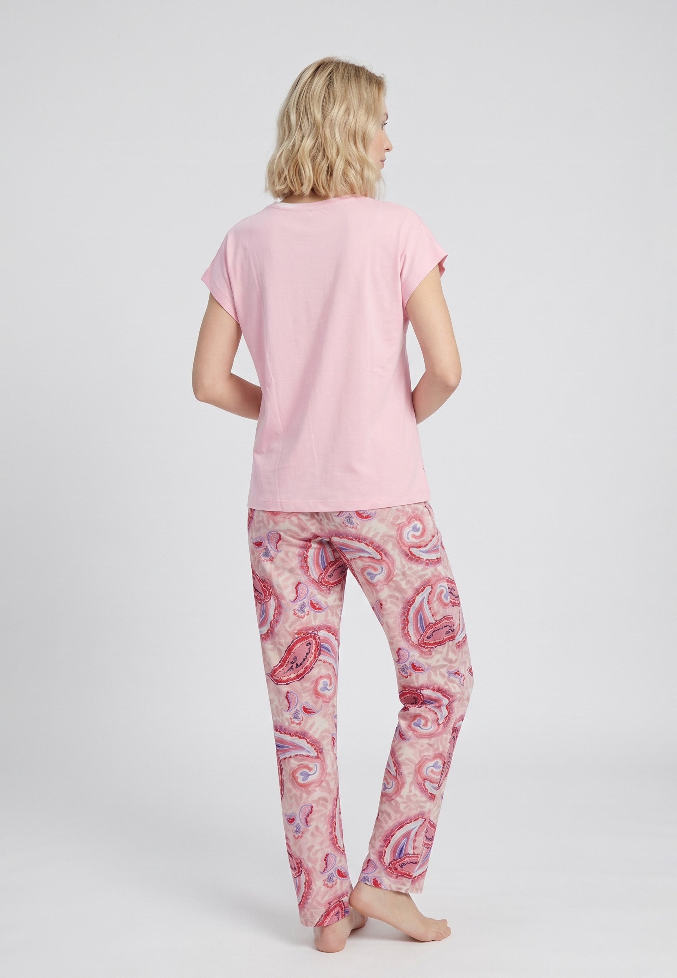 Femme portant un pyjama deux pièces t-shirt oversize col rond uni rose et pantalon droit imprimé paisley multicolore rose et rouge Rosabella Ethnique 2