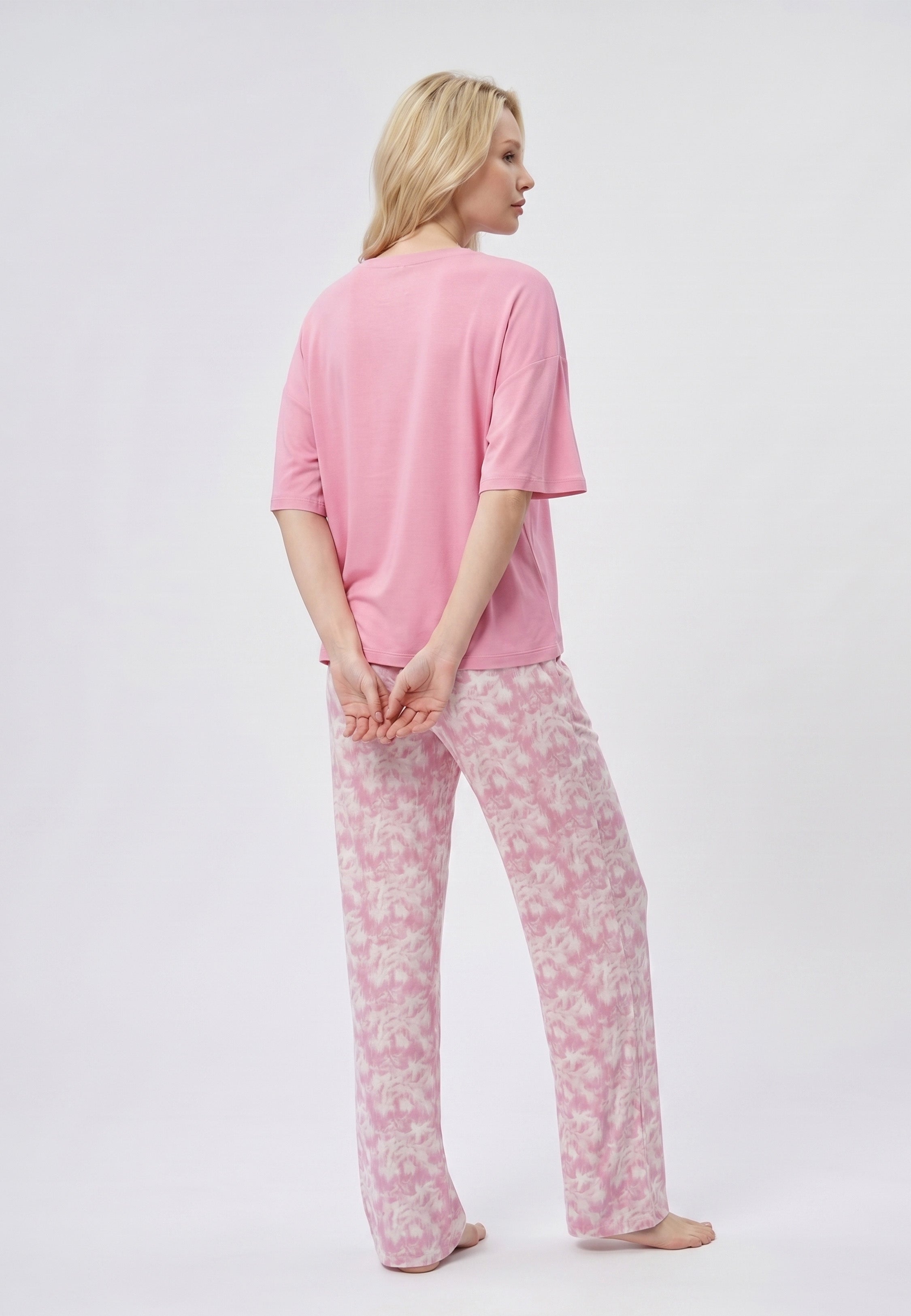 Femme portant un pyjama deux pièces t-shirt oversize rose uni et pantalon large imprimé aquarelle rose et blanc Rosabella Mellow Moments