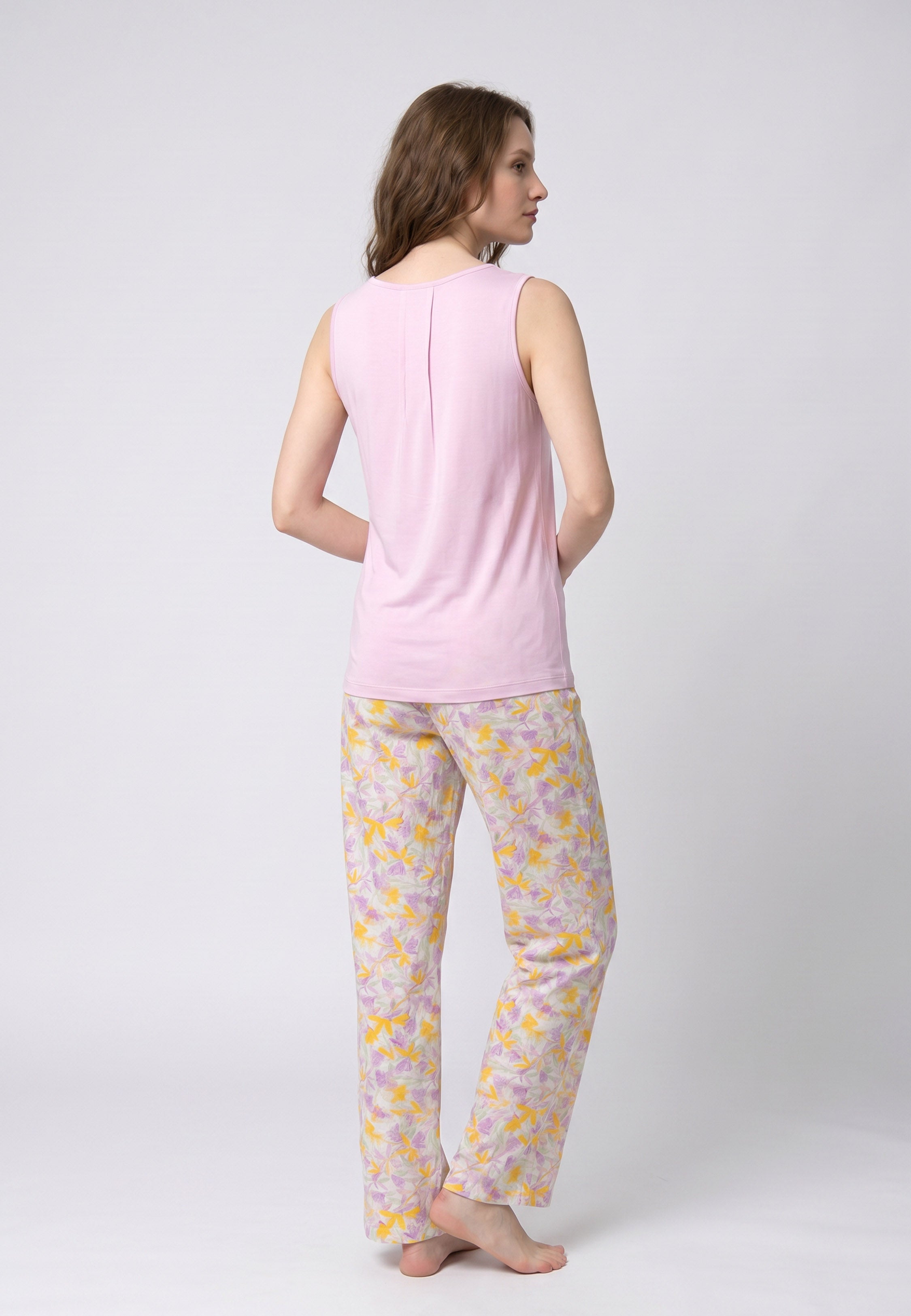 Femme portant un pyjama deux pièces débardeur col rond froncé uni mauve et pantalon long imprimé fleuri jaune mauve et vert Rosabella Chic Line
