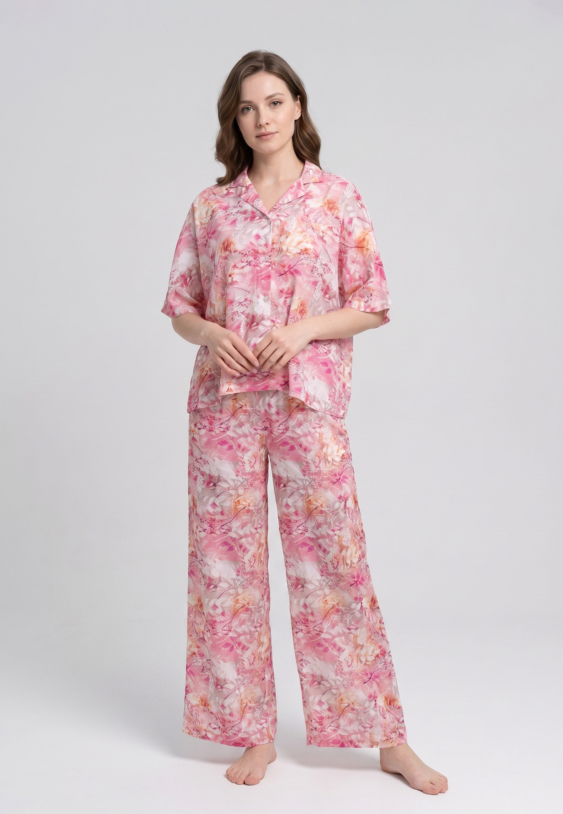 Femme portant un pyjama deux pièces chemise boutonnée col revers imprimé floral aquarelle rose et orangé et pantalon large assorti Rosabella Soft Reflections