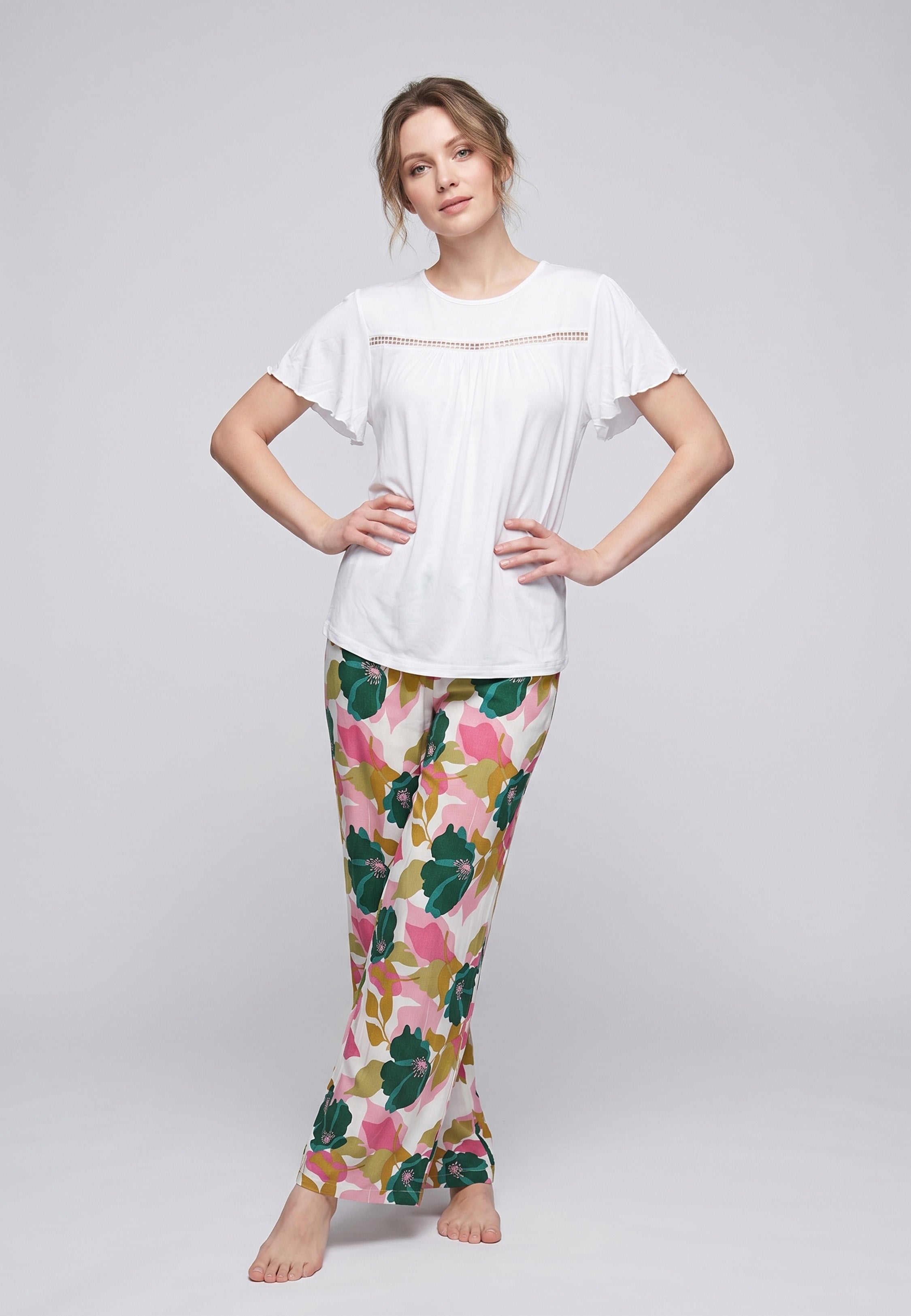 Femme portant un pyjama deux pièces t-shirt blanc manches volantées broderie anglaise et pantalon large grand imprimé floral coloré Rosabella Juliet Rose