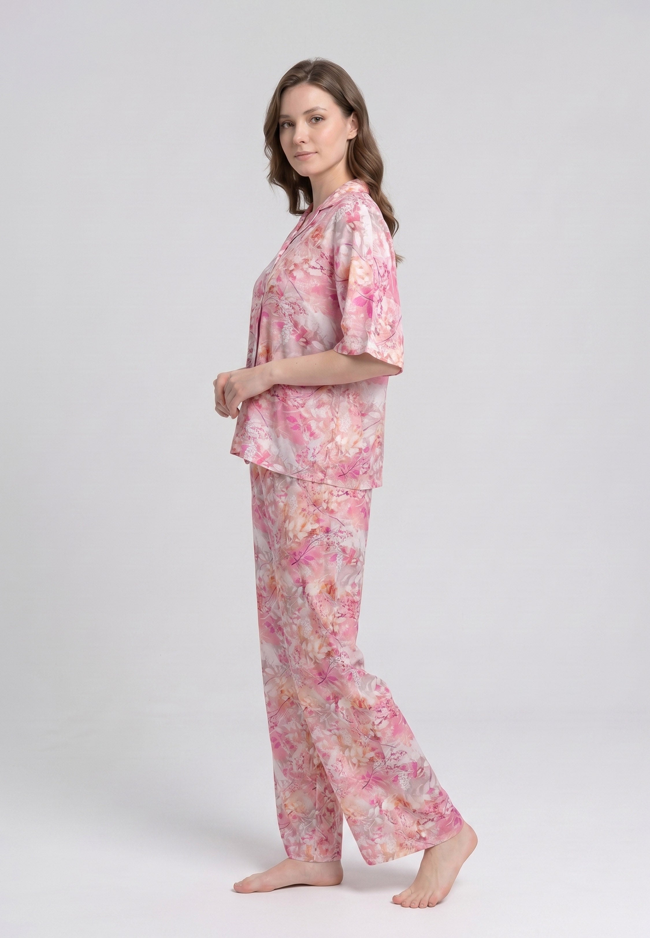 Femme portant un pyjama deux pièces chemise boutonnée col revers imprimé floral aquarelle rose et orangé et pantalon large assorti Rosabella Soft Reflections