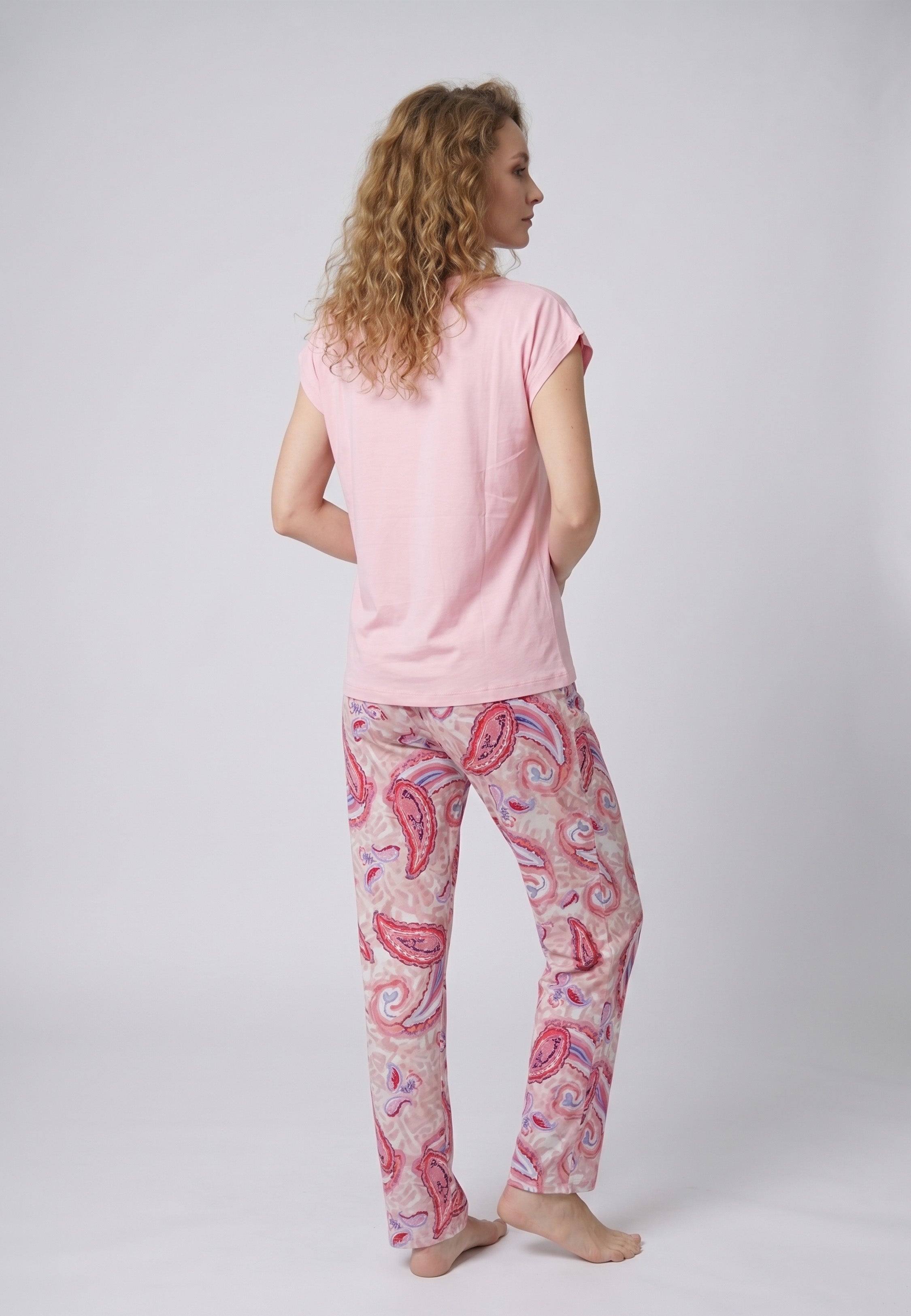 Femme portant un pyjama deux pièces top col V à lien frontal pompons uni rose et pantalon droit imprimé paisley multicolore rose et rouge Rosabella Ethnique 2