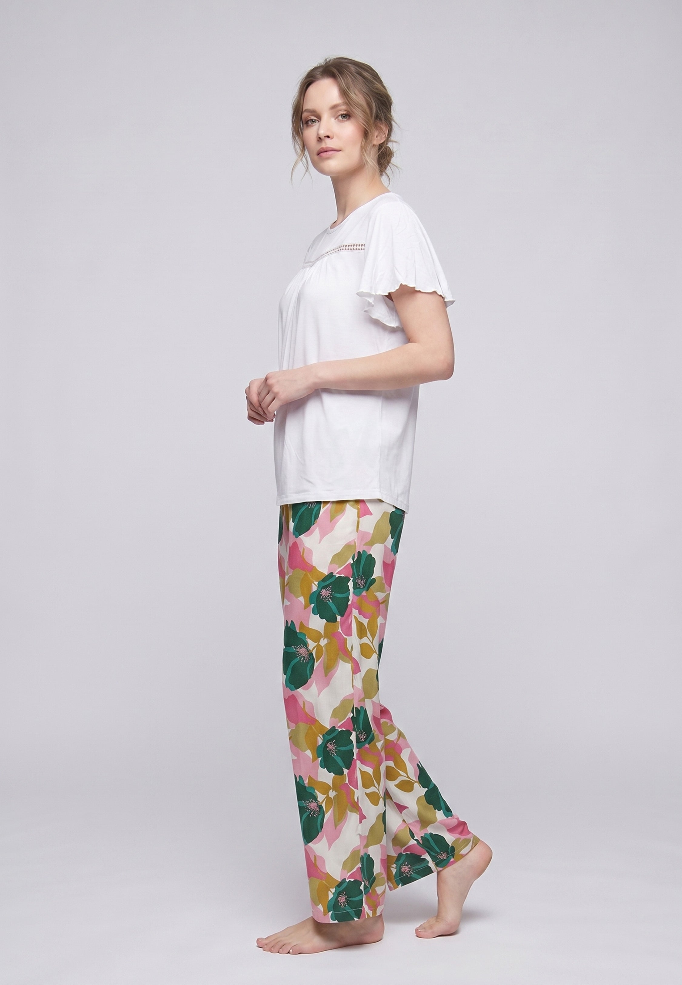 Femme portant un pyjama deux pièces t-shirt blanc manches volantées broderie anglaise et pantalon large grand imprimé floral coloré Rosabella Juliet Rose