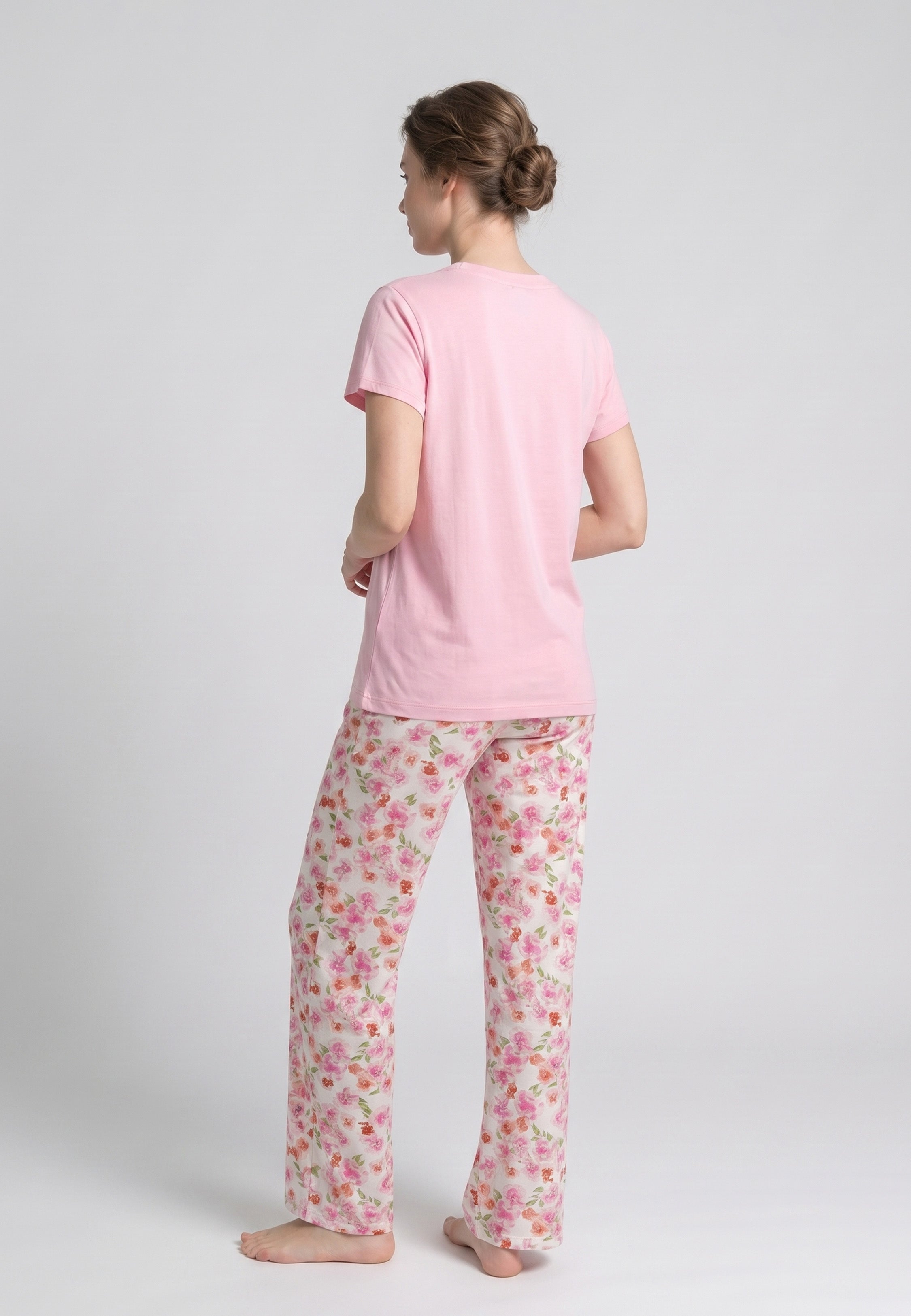 Femme portant un pyjama deux pièces t-shirt col V fuchsia uni et pantalon large imprimé aquarelle fuchsia et blanc Rosabella Mellow Moments