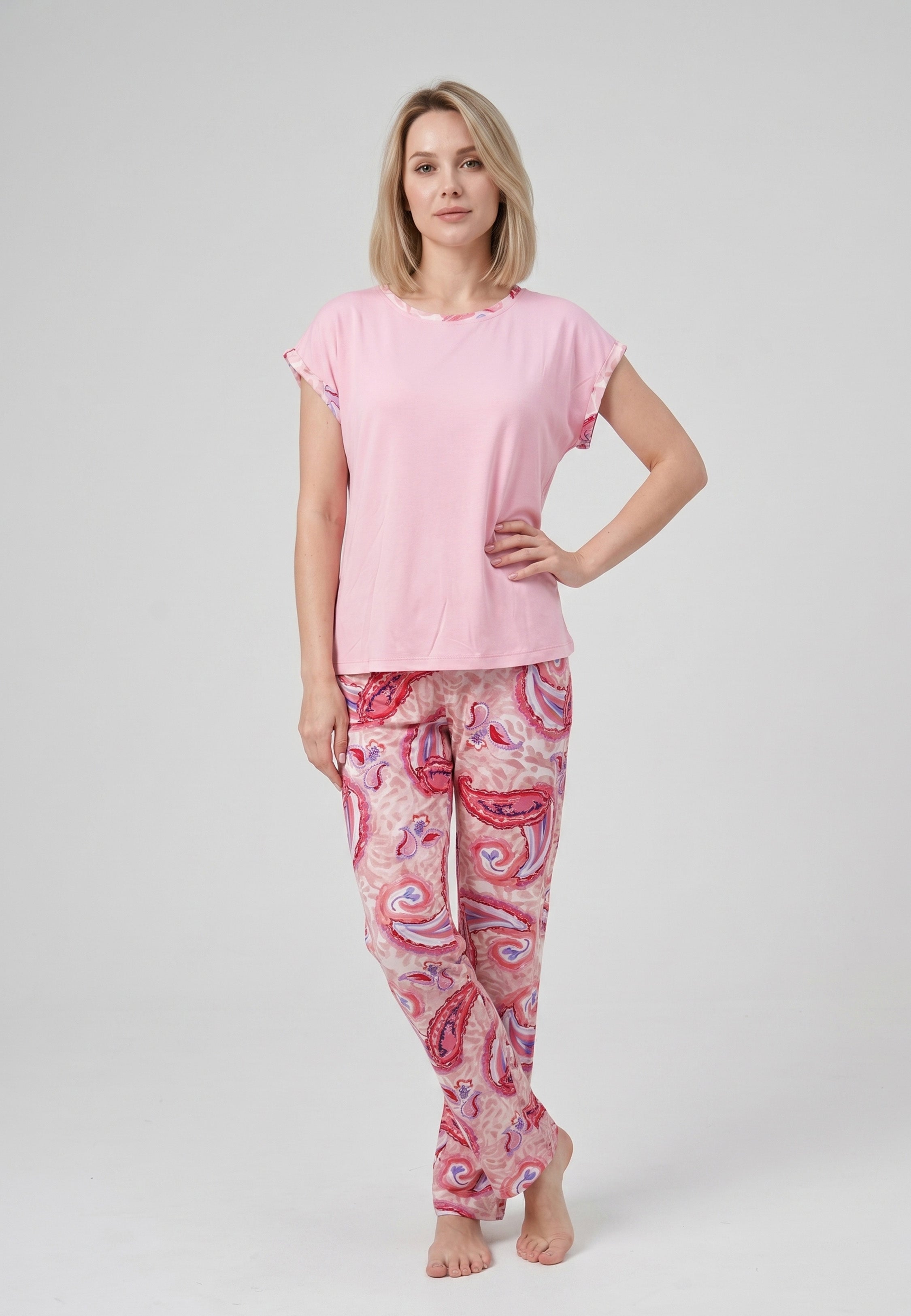 Femme portant un pyjama deux pièces t-shirt col rond uni rose liseré imprimé paisley et pantalon droit imprimé paisley multicolore rose et rouge Rosabella Ethnique 2