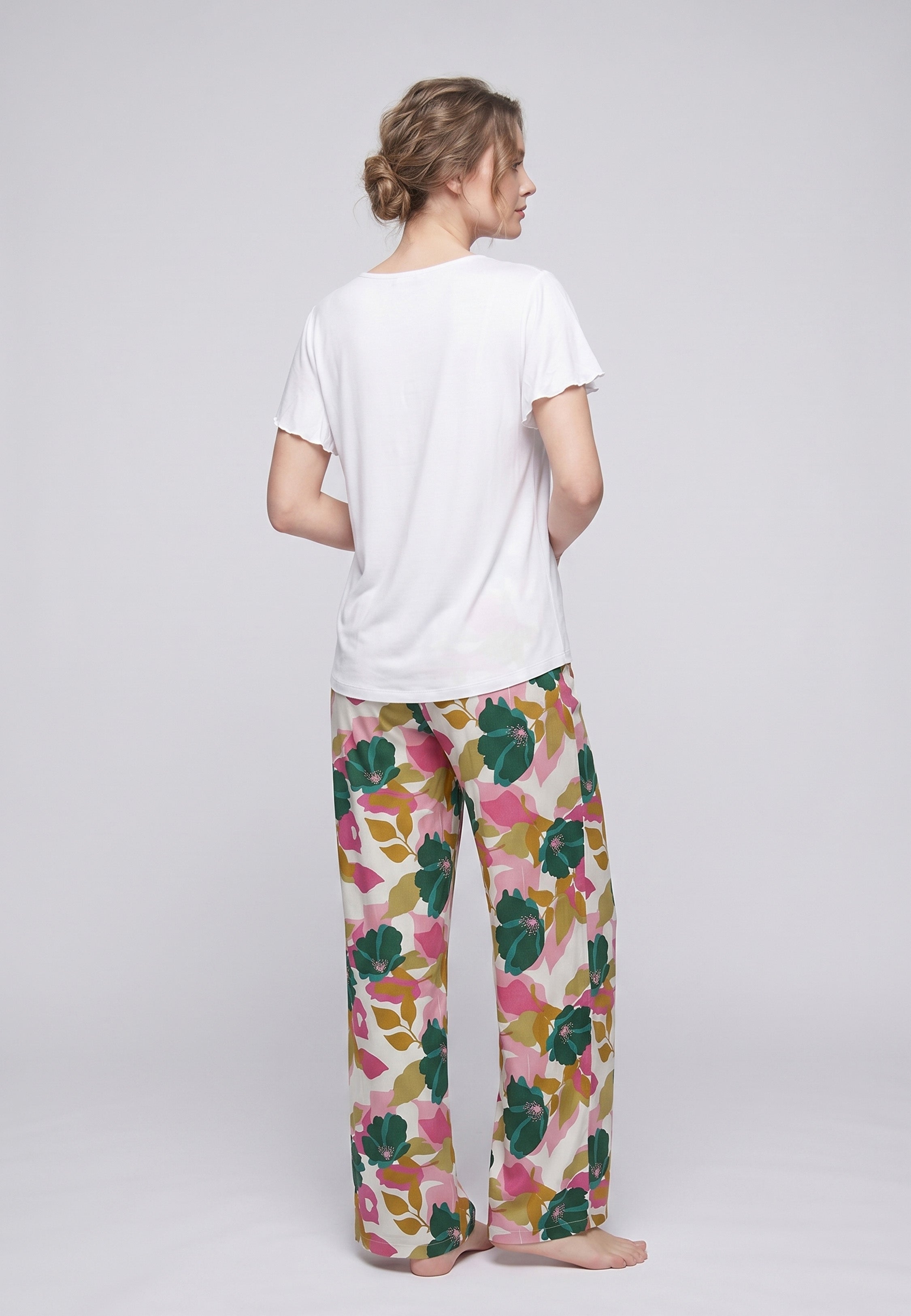 Femme portant un pyjama deux pièces t-shirt blanc manches volantées broderie anglaise et pantalon large grand imprimé floral coloré Rosabella Juliet Rose