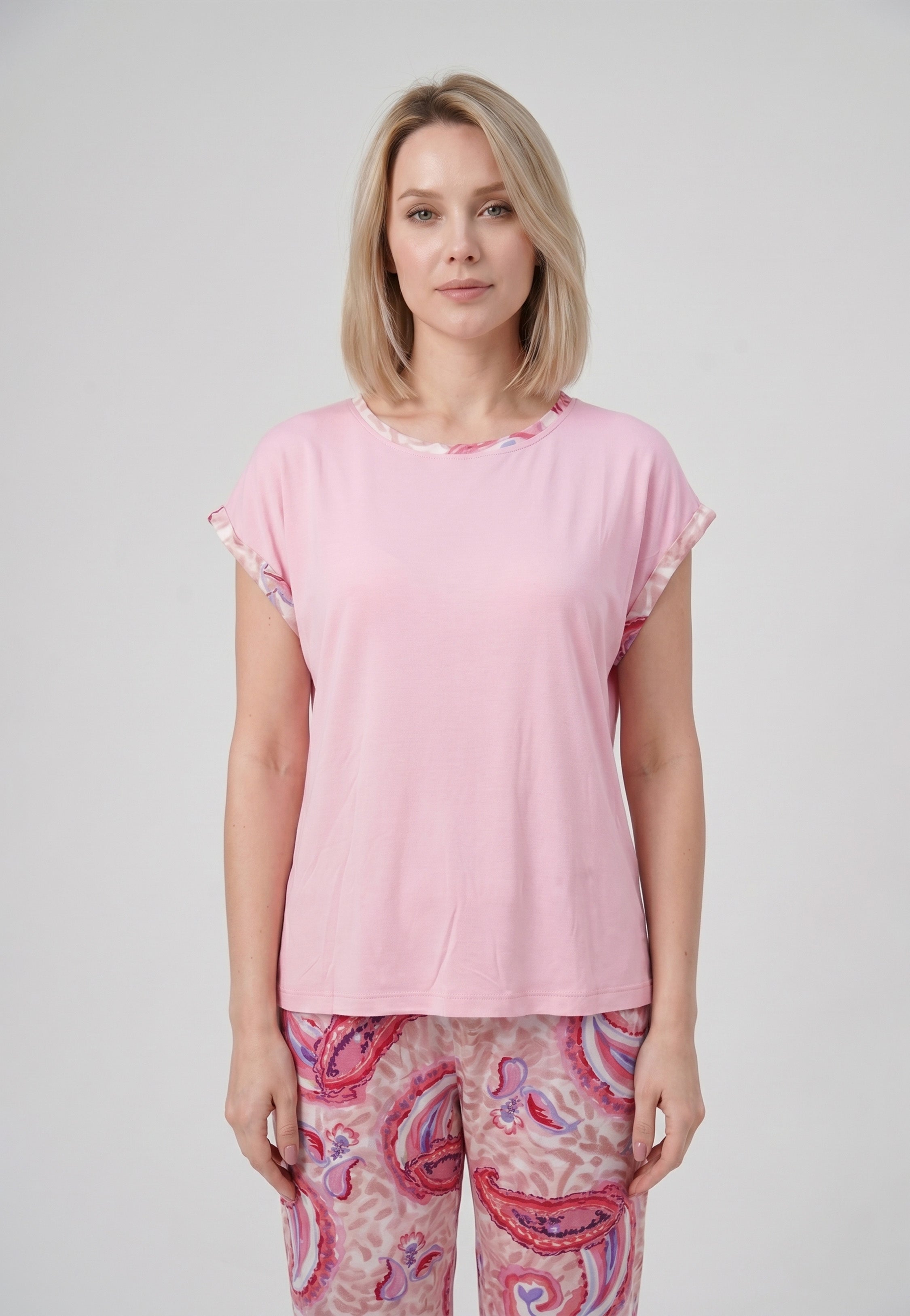 Femme portant un pyjama deux pièces t-shirt col rond uni rose liseré imprimé paisley et pantalon droit imprimé paisley multicolore rose et rouge Rosabella Ethnique 2