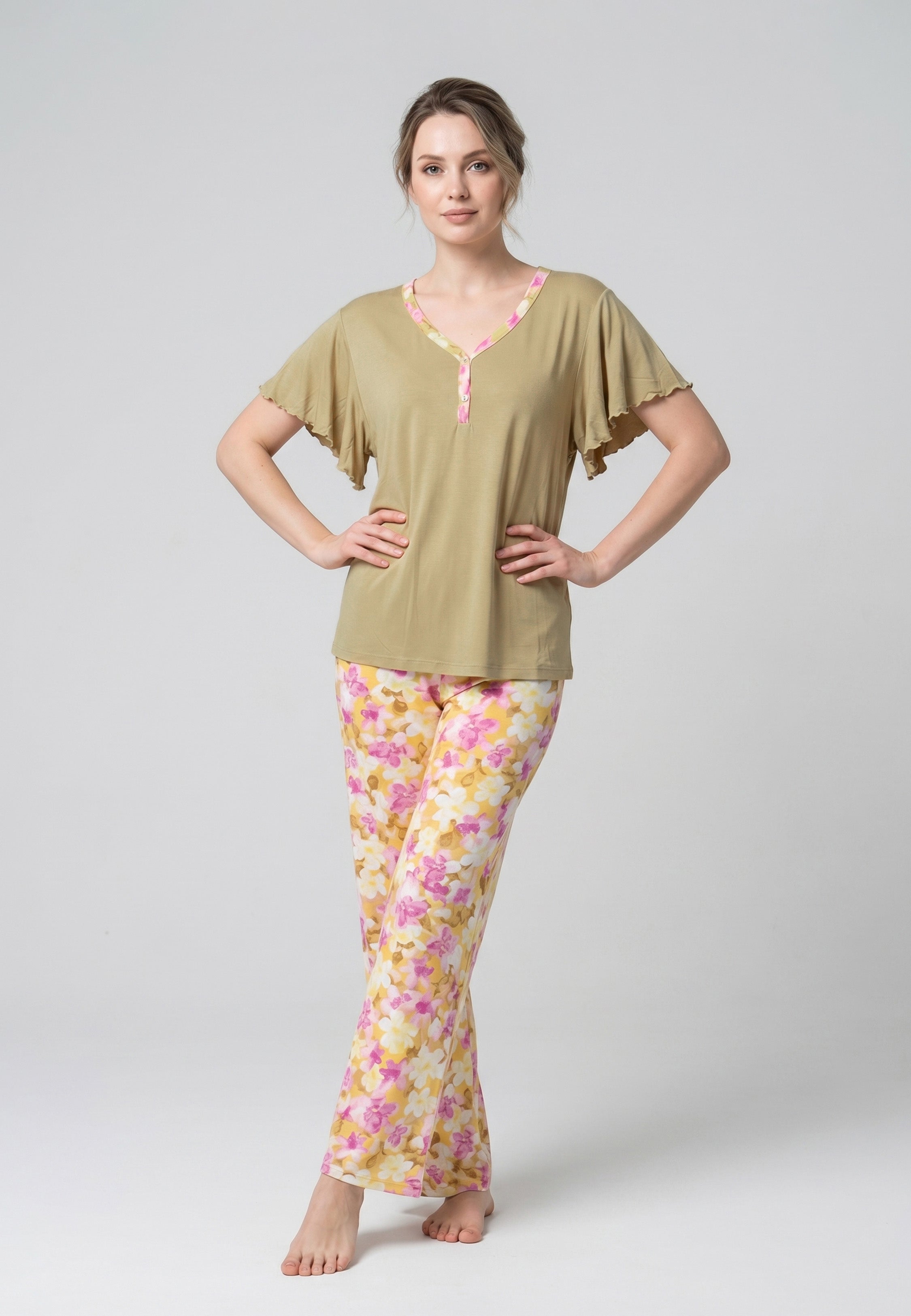 Femme portant un pyjama deux pièces haut kaki manches papillon et pantalon à imprimé floral rose et jaune